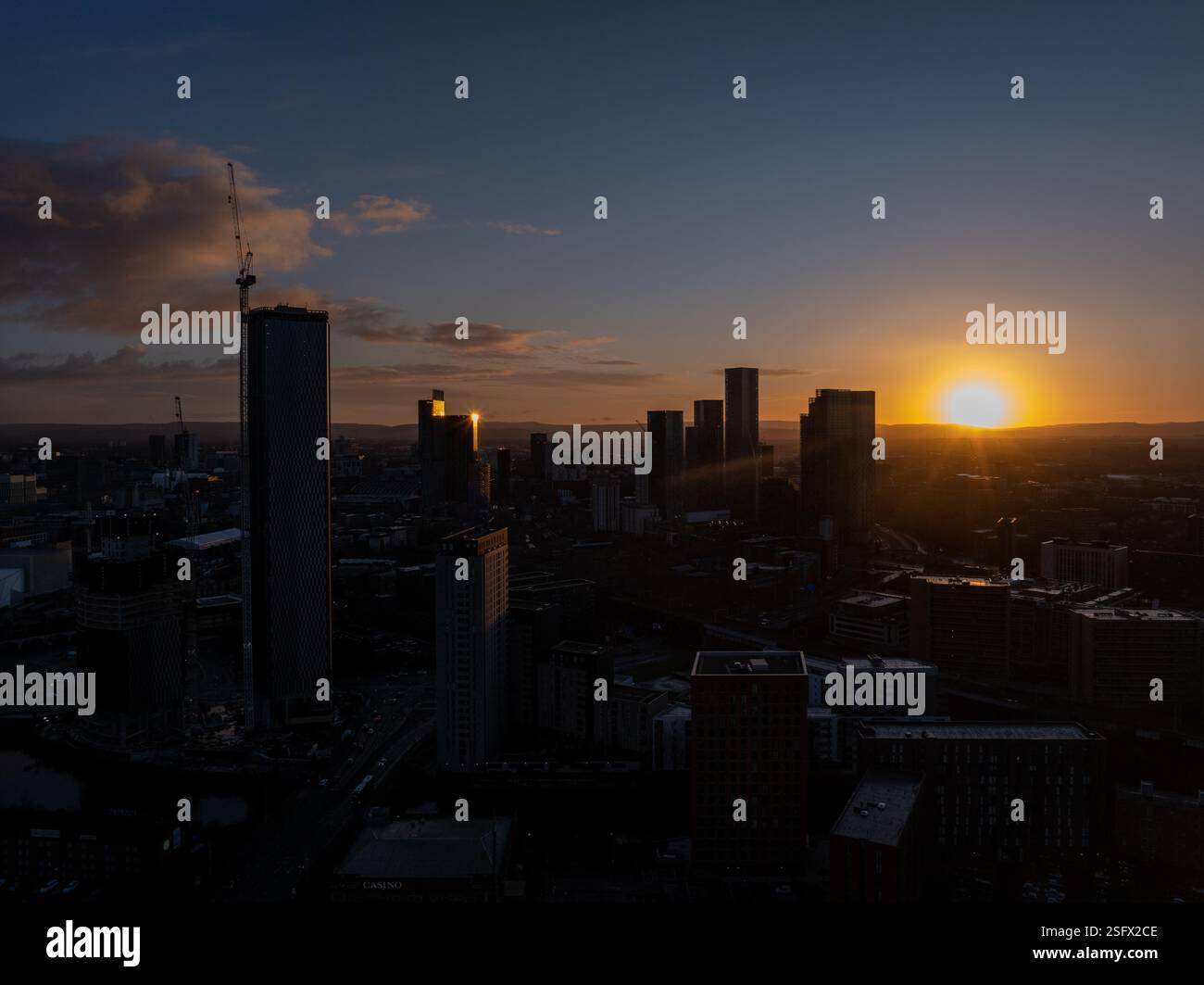 Illustrazione del centro di Manchester durante il tramonto, che mostra il paesaggio urbano moderno e gli alti grattacieli che si stagliano contro il cielo luminoso della sera, Foto Stock