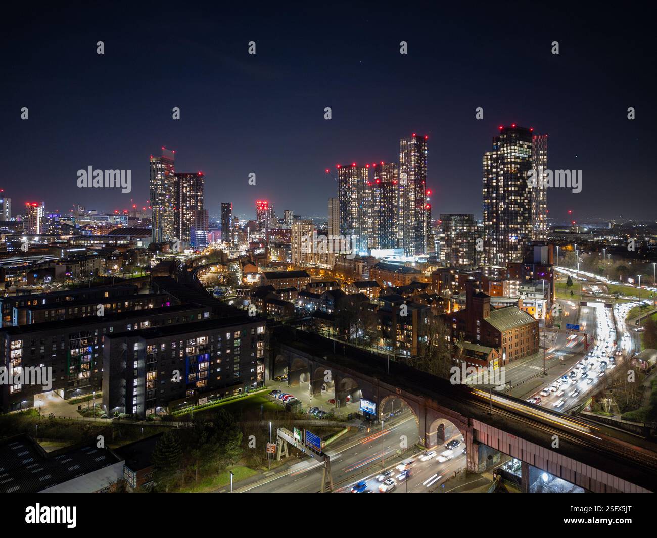 Uno scintillante paesaggio urbano di Manchester che mostra grattacieli illuminati, strade affollate e moderni design urbani, raffiguranti la vibrazione e il fascino del nostro hotel Foto Stock