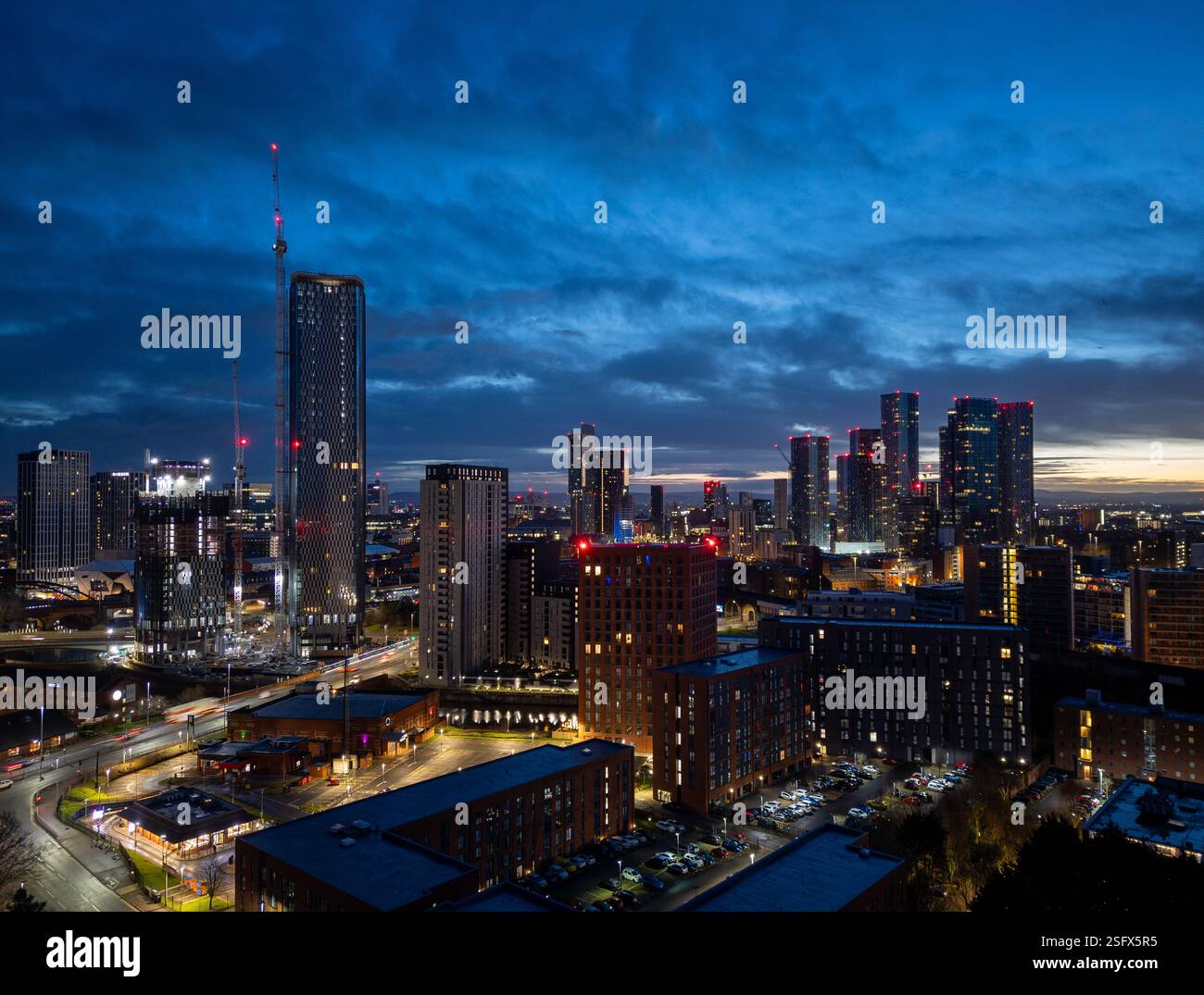 Un'accattivante vista al crepuscolo del centro di Manchester, che mostra moderni grattacieli, luci urbane e vivace vita cittadina catturata contro uno spettacolare twil Foto Stock