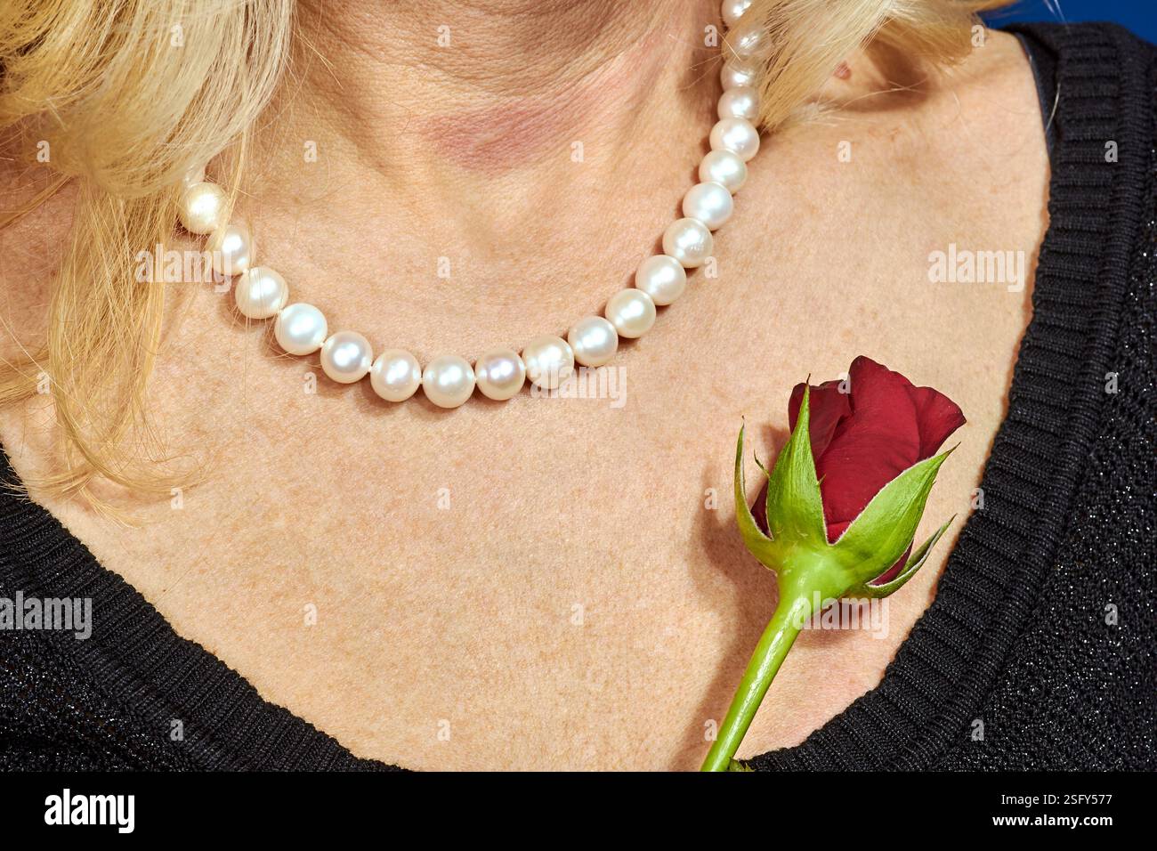 rosa rossa e ragazza con collana di perle Foto Stock