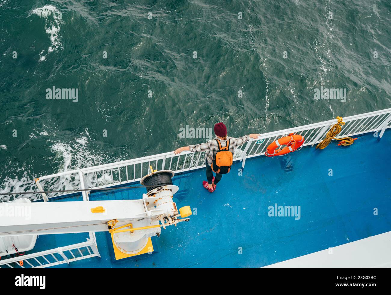 Donna con zaino che gode dei paesaggi del Mare del Nord sul traghetto norvegese durante il viaggio dalla Danimarca. La scena cattura l'essenza del viaggio rilassato, l'esplorazione i Foto Stock