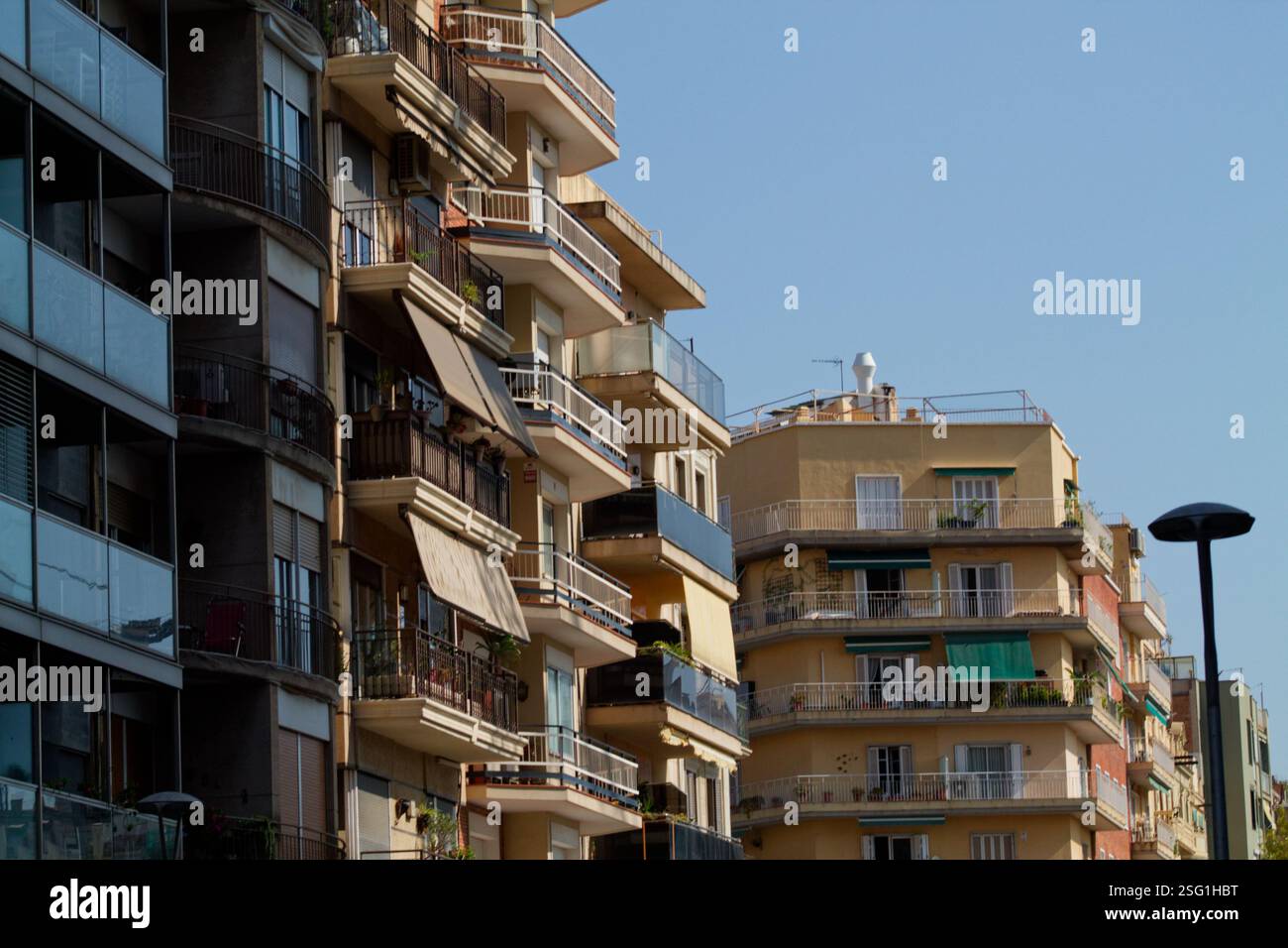 Una vista degli edifici di appartamenti urbani con balconi e stili architettonici variabili sotto un cielo azzurro. Foto Stock