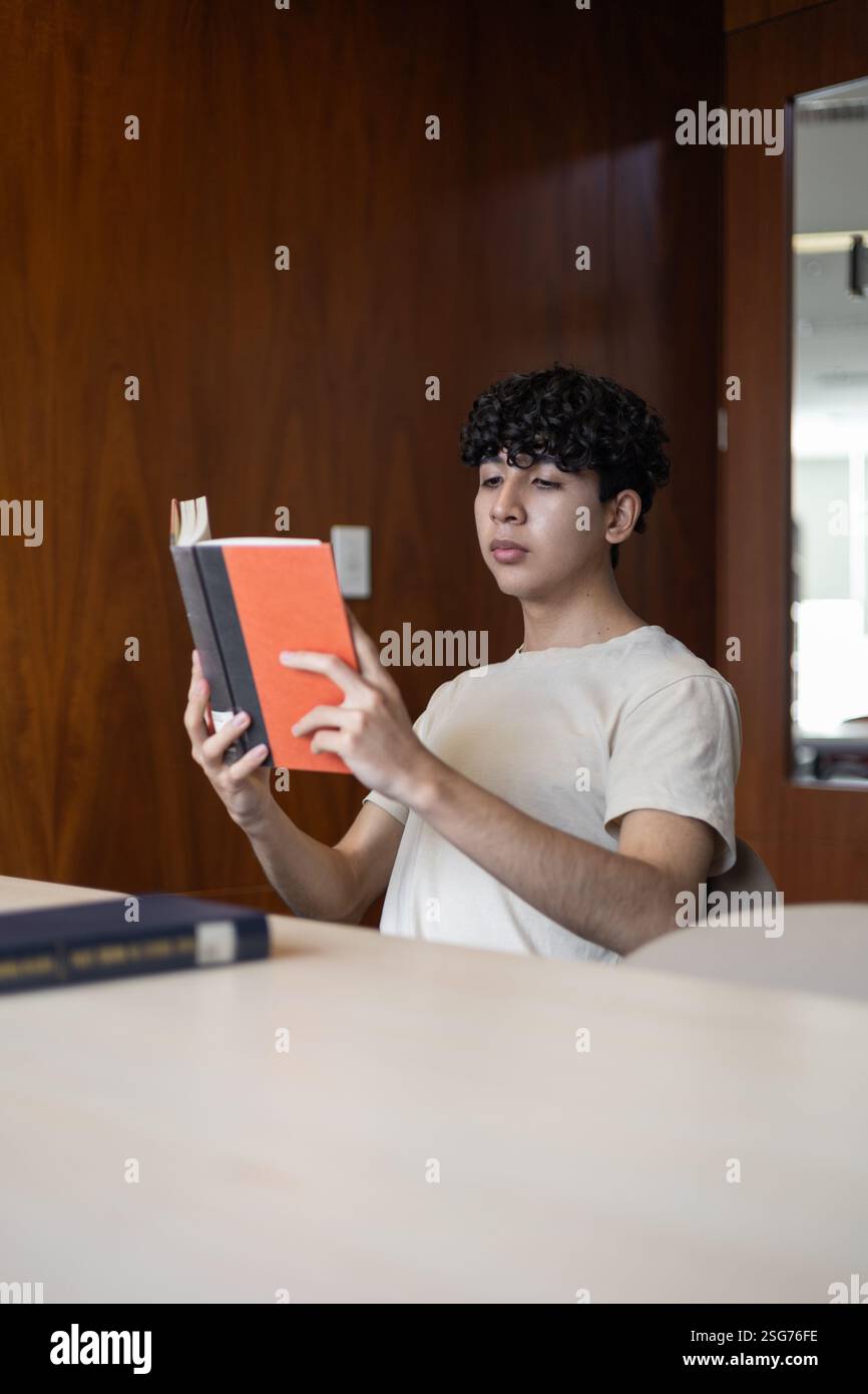 Uno studente universitario che rivede le note, si prepara per gli esami. Perfetto per temi quali istruzione, sessioni di studio, dedizione accademica e vita universitaria. Foto Stock