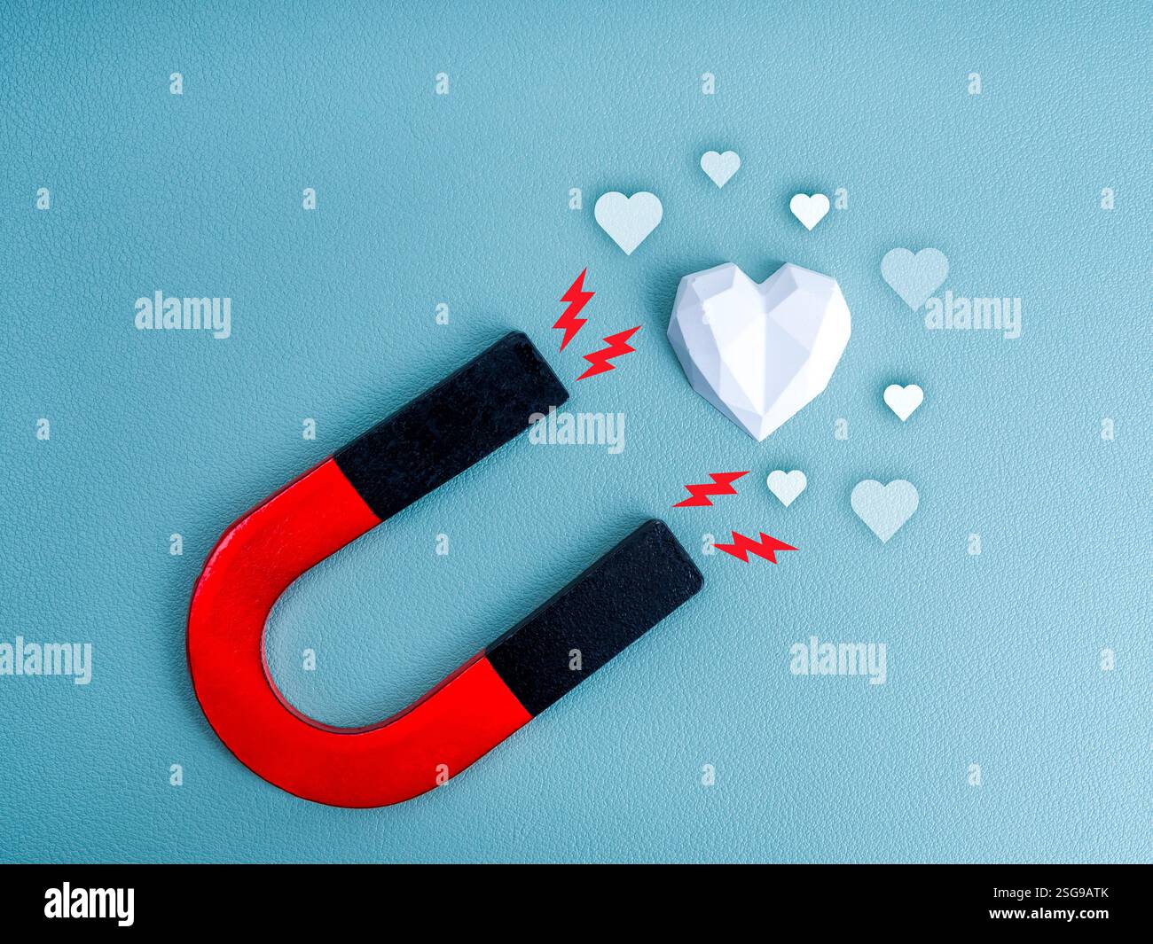 Magnete a forma di U, colori nero e rosso con icona scintillante, potenza che attira il bianco dal cuore forte, con icona amore su sfondo blu. Truffa romantica, uomini Foto Stock