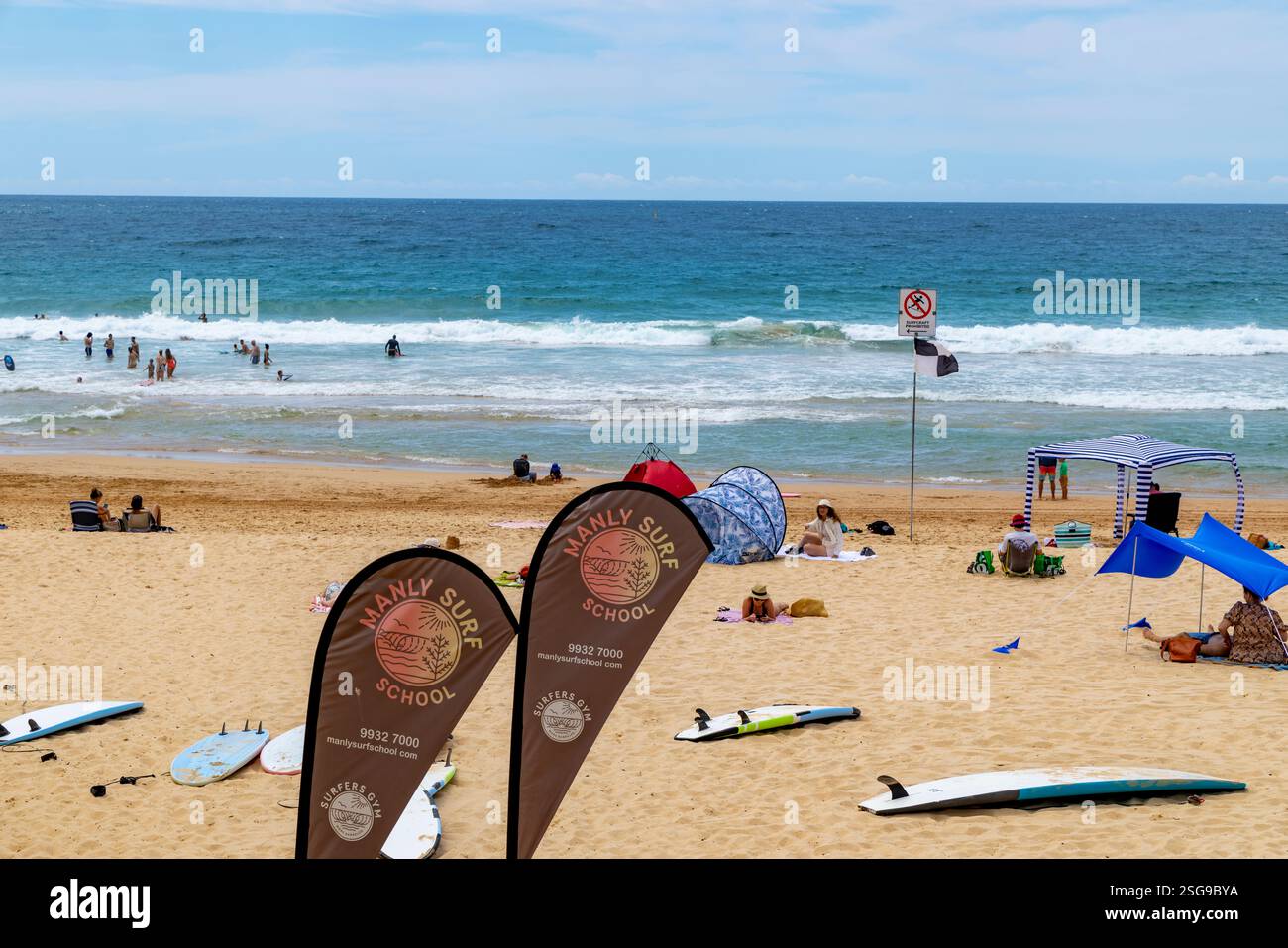 La scuola di surf Manly sulla spiaggia di Manly a Sydney offre lezioni di surf per principianti su tavole da surf nell'oceano, Sydney, NSW, Australia, 2025 Foto Stock