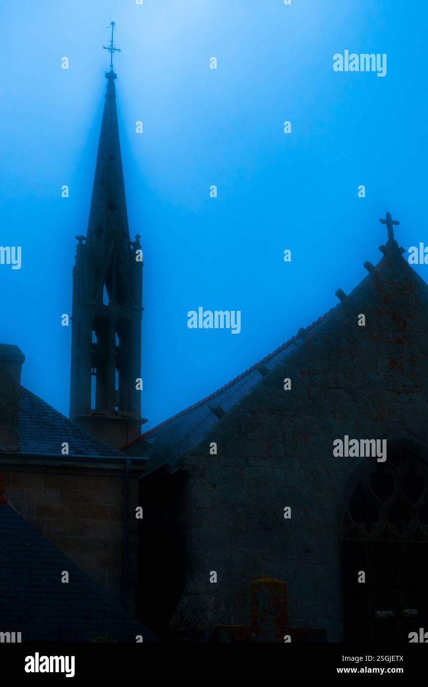 Una chiesa nebbiosa situata a Tudy, Bretagna, nel nord della Francia Foto Stock