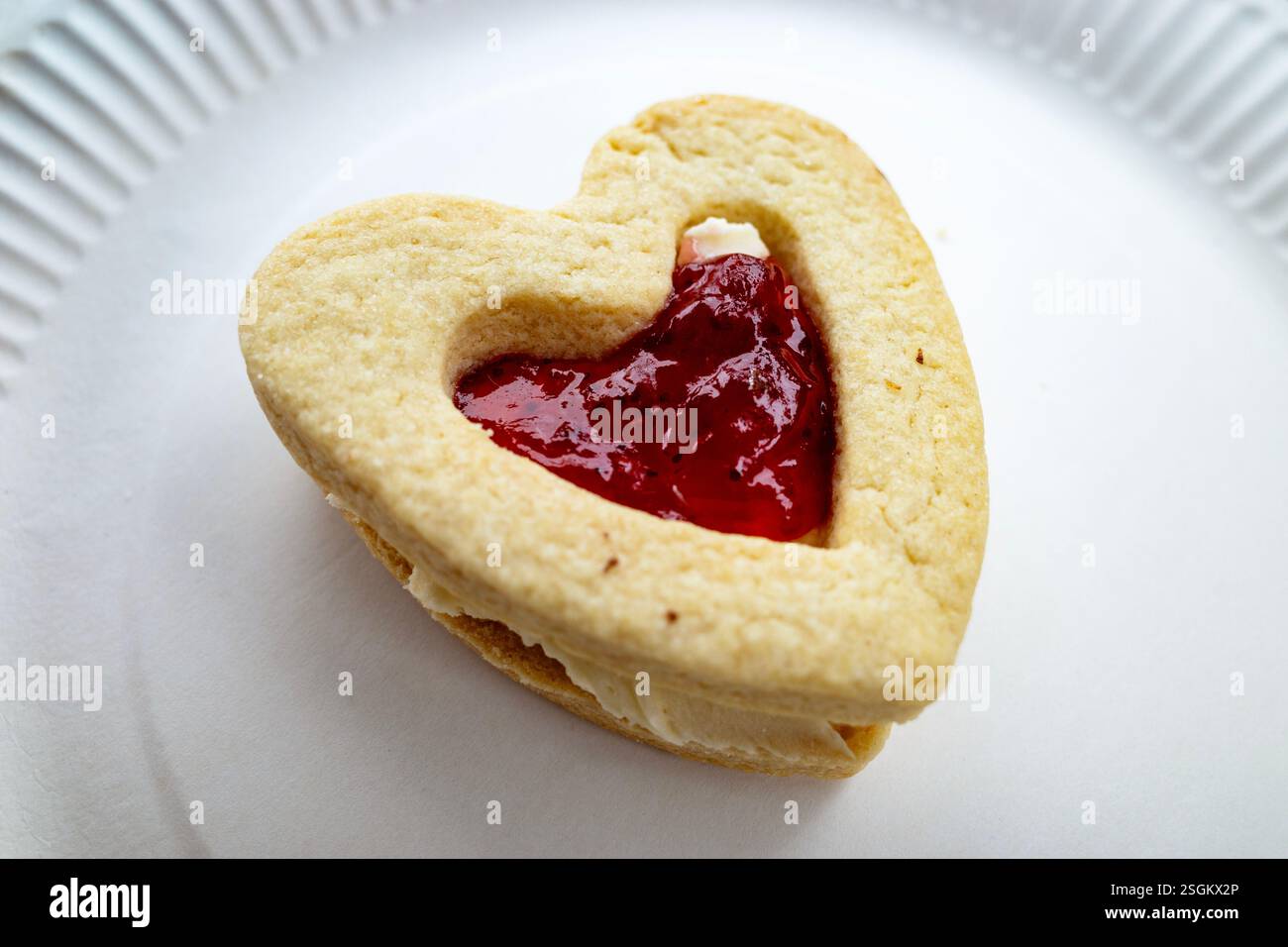 Cuore di pasta frolla ripieno di marmellata e panna Foto Stock