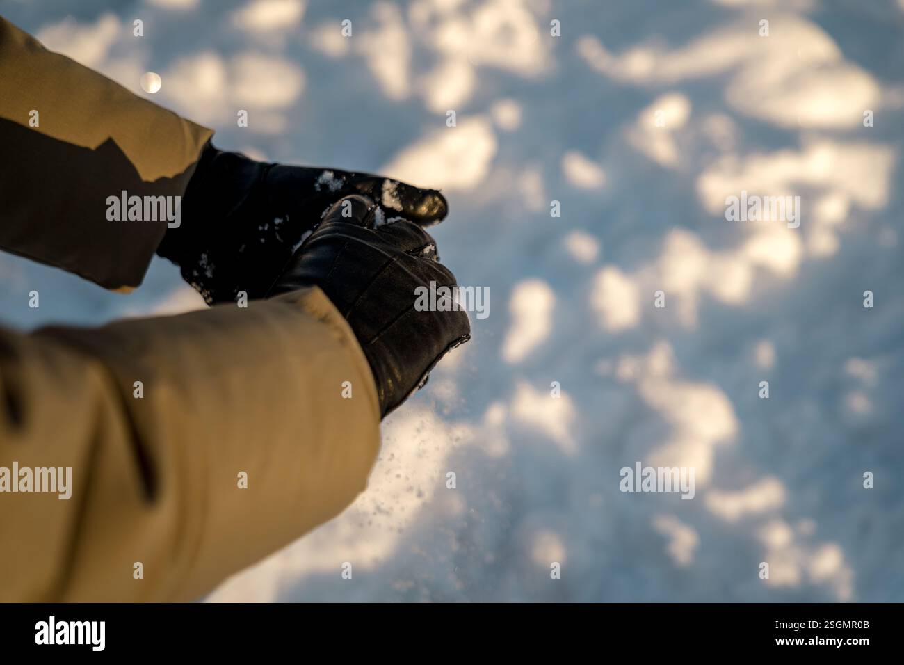 Mani che formano una palla di neve su un terreno innevato a Oslo Foto Stock