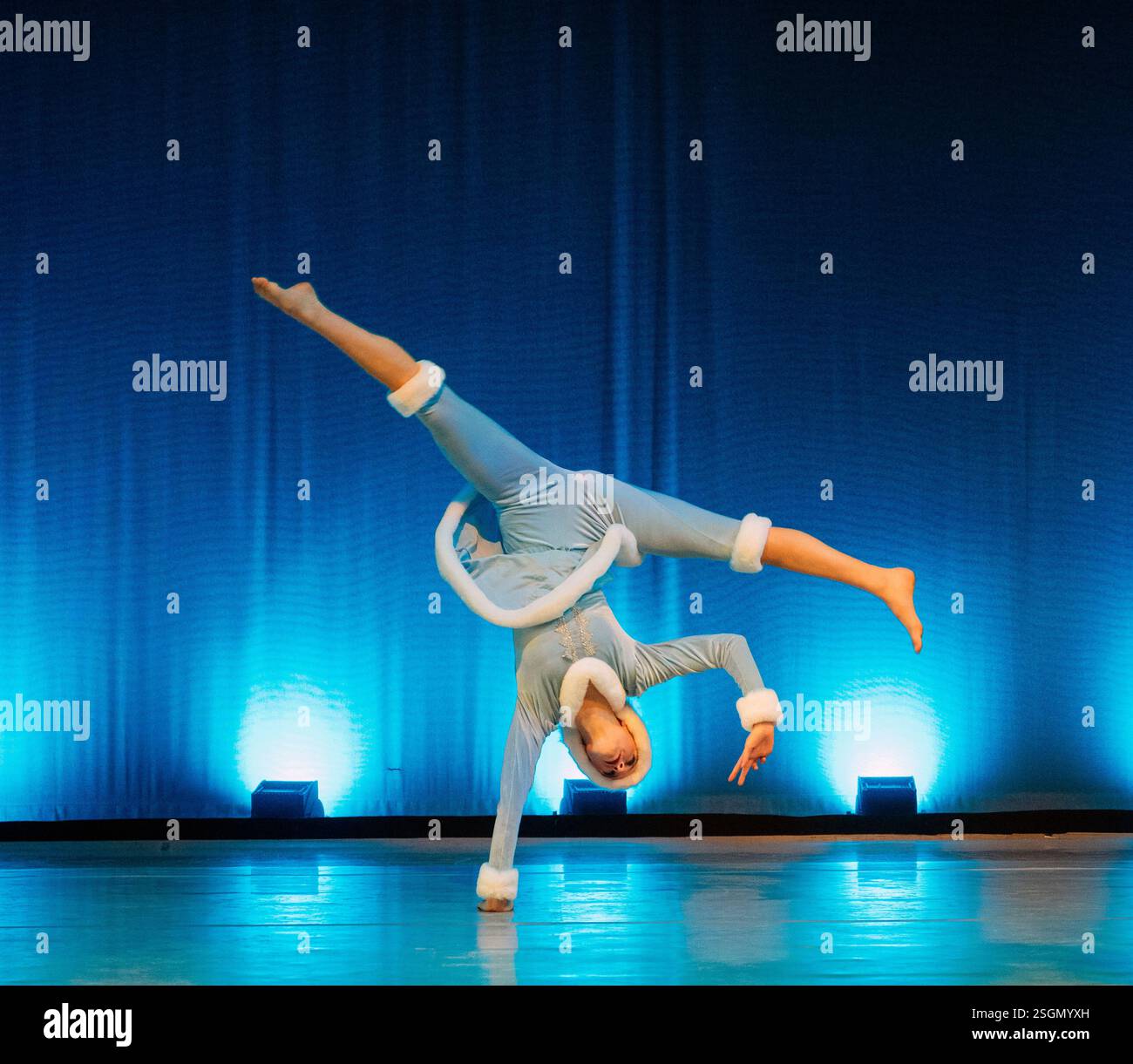 Acrobata in costume blu che esegue un cartoncino con una sola mano su un palcoscenico illuminato. Lo Schiaccianoci, Bainbridge Island, Stati Uniti Foto Stock