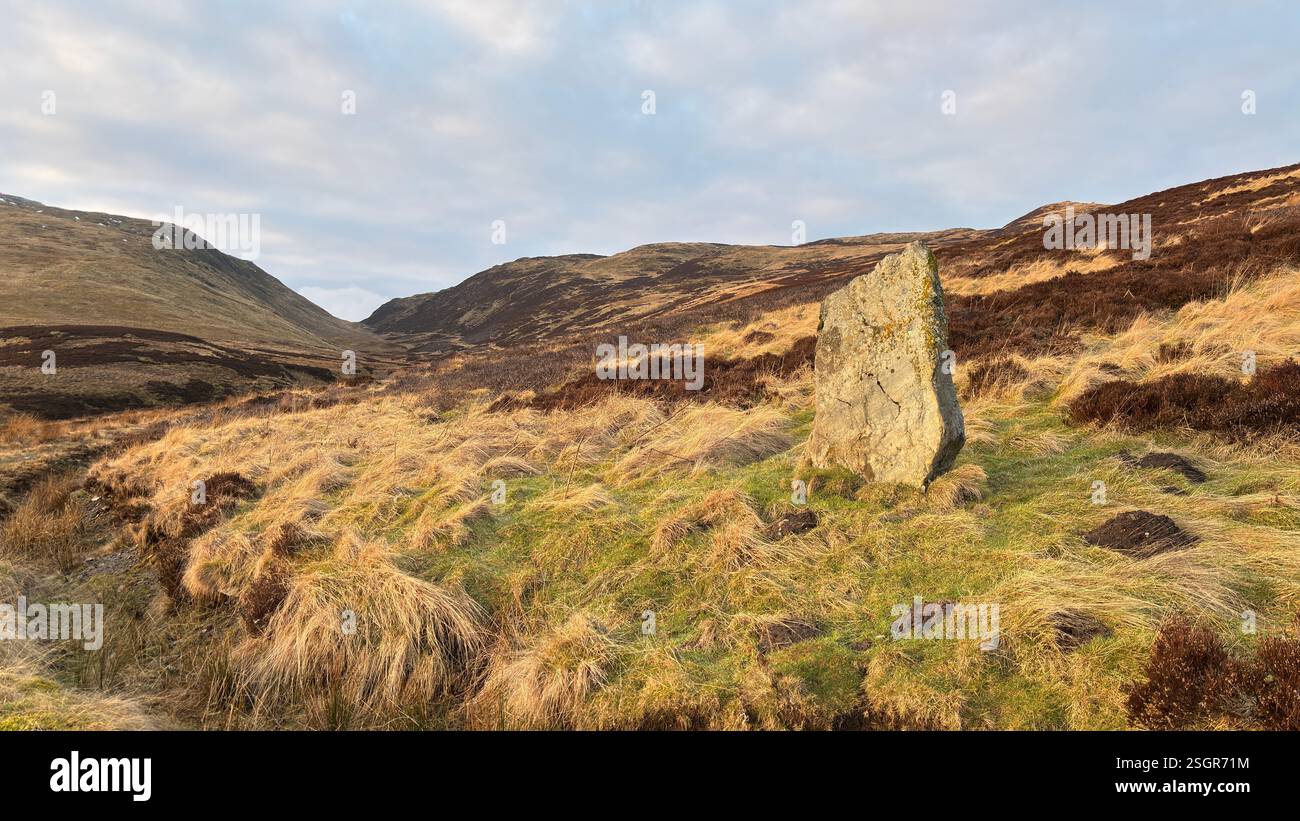 Standing Stone sulle montagne scozzesi delle Highland in inverno con la neve. Colline ondulate all'aperto in Scozia. Vista sulla natura selvaggia e sulla splendida atmosfera - Immagine stock catturata con smartphone