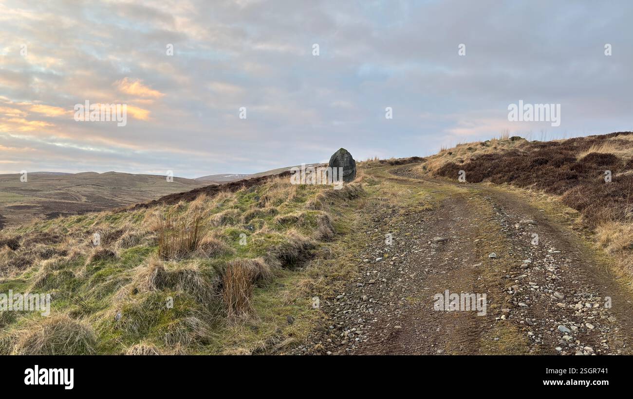 Standing Stone sulle montagne scozzesi delle Highland in inverno con la neve. Colline ondulate all'aperto in Scozia. Vista sulla natura selvaggia e sulla splendida atmosfera - Immagine stock catturata con smartphone