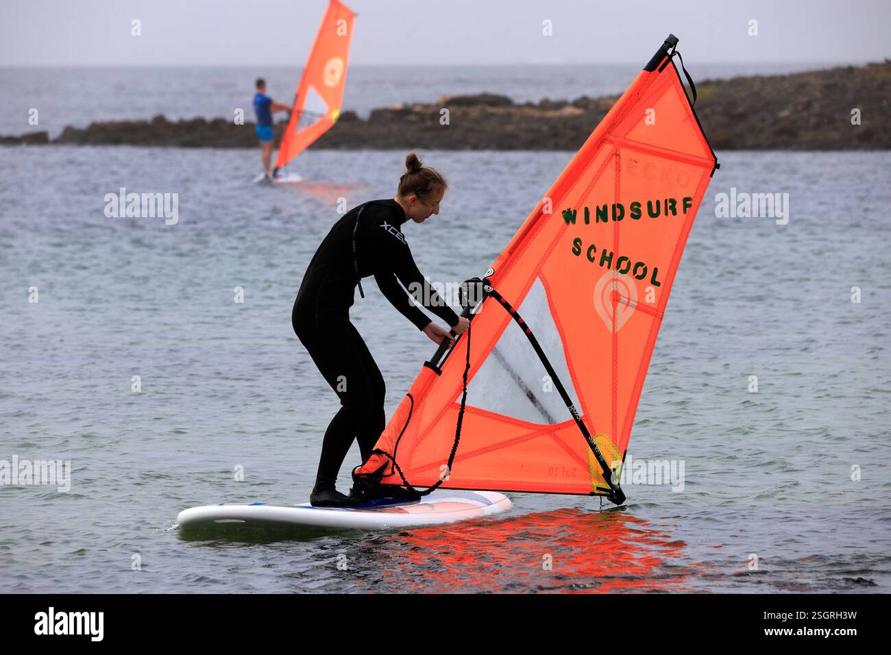 Donna che impara a praticare windsurf, scuola di windsurf, El Cotillo, Fuerteventura, Isole Canarie, Spagna. Foto Stock