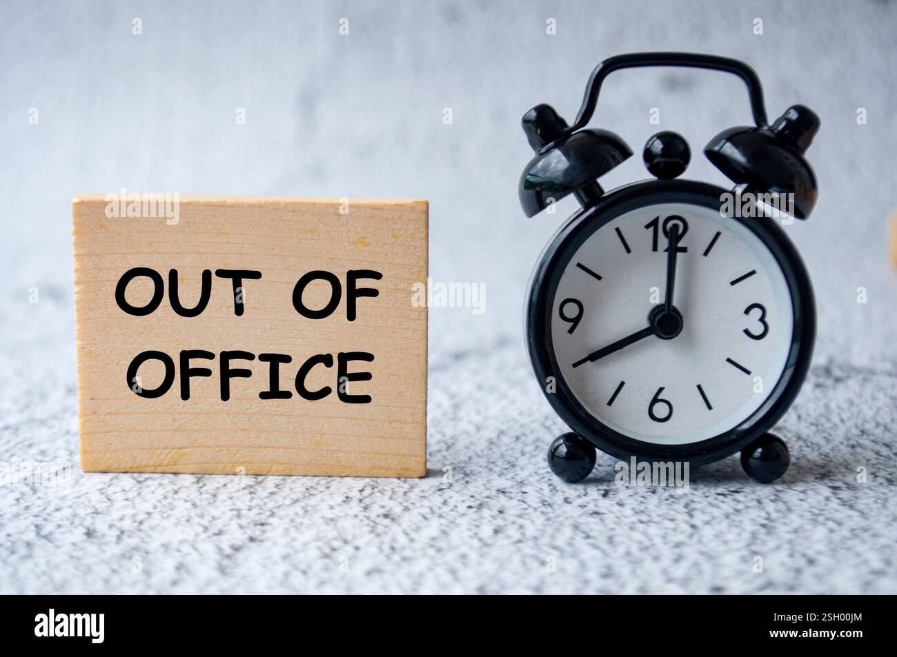 Testo fuori sede su un quadrato di legno con sfondo orologio da tavolo. Foto Stock