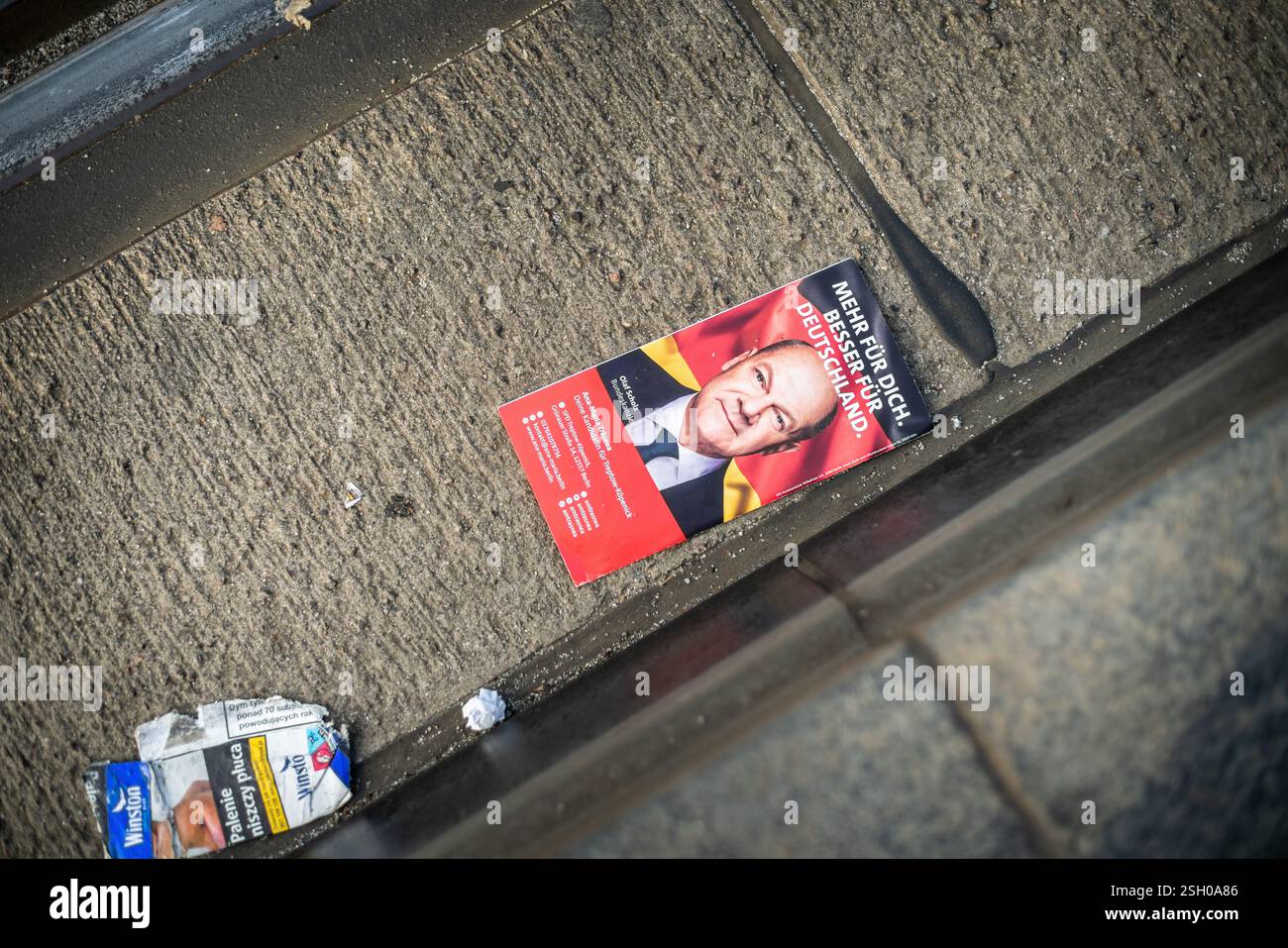 Berlino, Germania. 10 febbraio 2025. Un opuscolo elettorale scartato del SPD (Social Democratici / Partito Socialdemocratico di Germania) con Olaf Scholz, l'attuale Cancelliere della Germania, si trova accanto ai binari del tram a Berlino. Questa immagine simboleggia il declino della popolarità di Scholz e del suo partito negli ultimi cinque anni. Foto Stock
