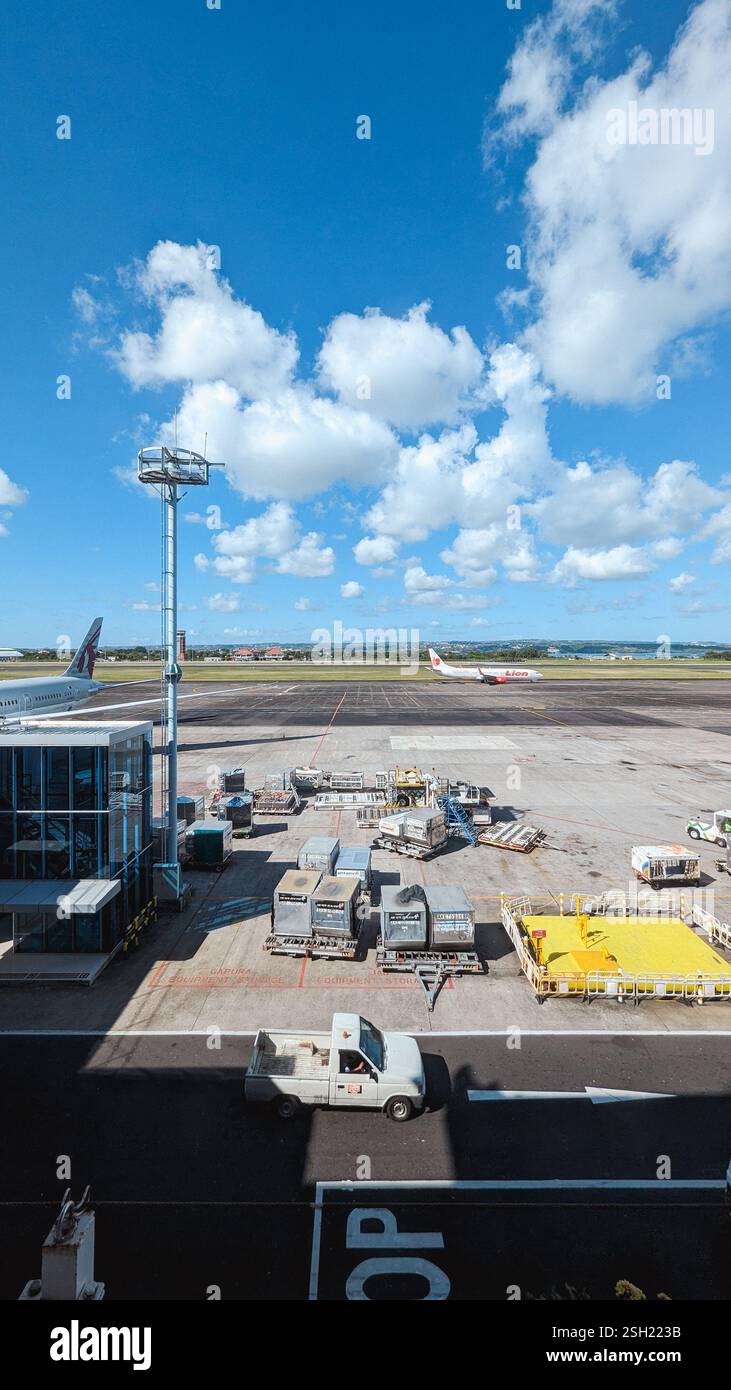 Affollato aeroporto con aerei e attrezzature di supporto a terra Foto Stock