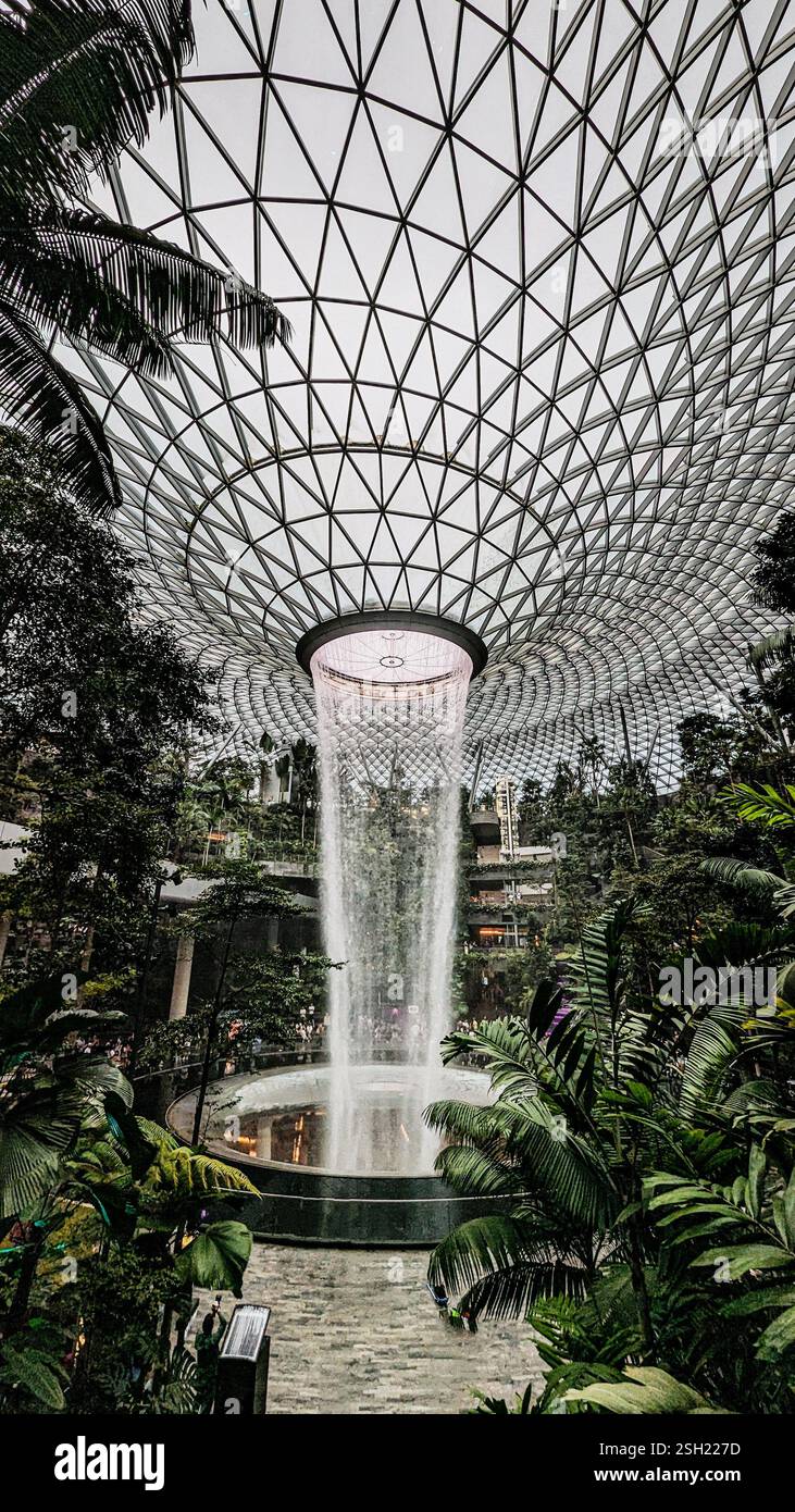 Cascata al coperto in un ambiente architettonico moderno, Jewel Changi Airport: La cascata al coperto più grande del mondo, il vortice della pioggia Foto Stock