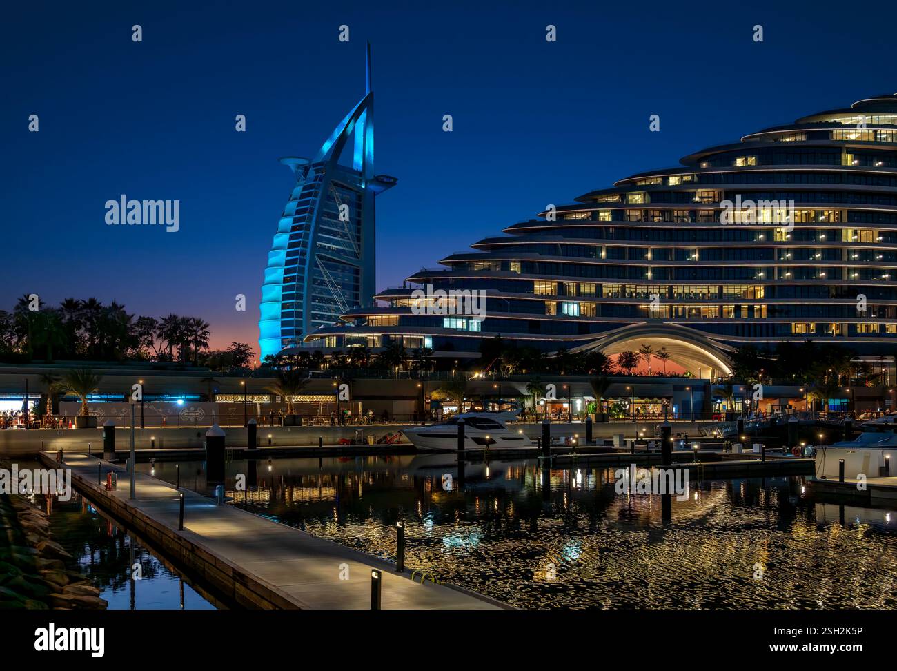Il Burj al Arab di Dubai è stato girato dalla Marsa al Arab Walk, accanto alla Marsa al Arab Marina. In primo piano si trova l'hotel Jumeirah Marsa al Arab. Foto Stock