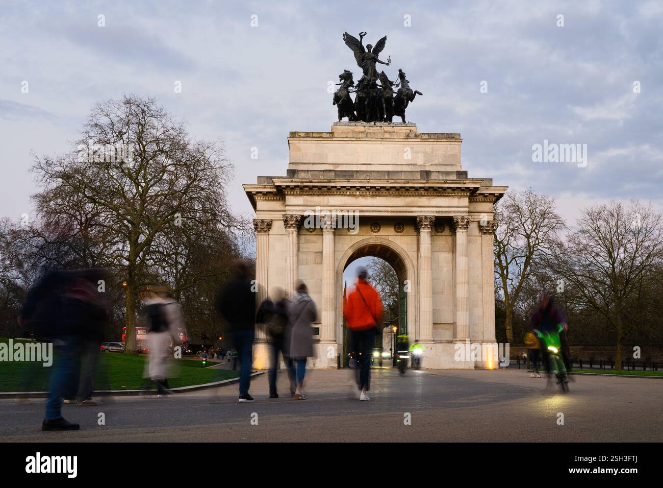 Londra, Regno Unito - 22 marzo 2024; ombre serali di persone che passano il Wellington Arch a Londra Foto Stock