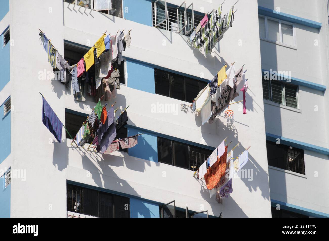 Lavare appeso su lunghe linee di lavaggio per asciugare nel clima tropicale su alti blocchi di appartamenti rialzati a Singapore Foto Stock