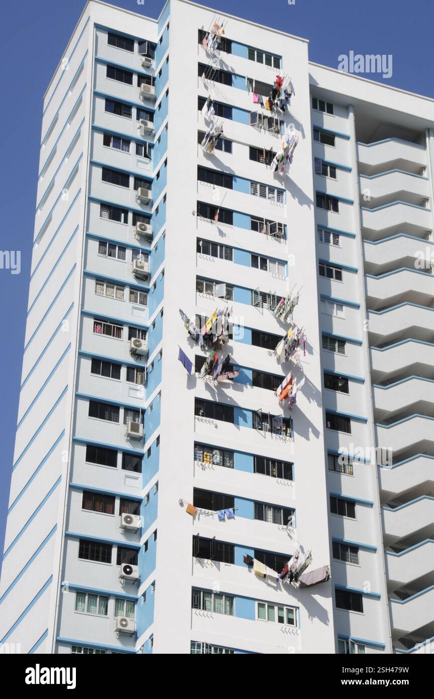 Lavare appeso su lunghe linee di lavaggio per asciugare nel clima tropicale su alti blocchi di appartamenti rialzati a Singapore Foto Stock