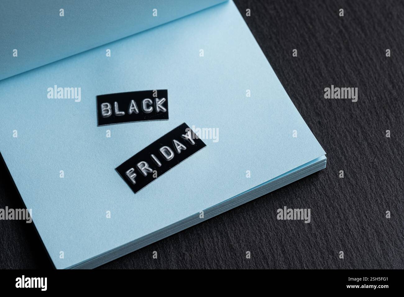 Etichetta Black friday su busta blu su sfondo nero con spazio per le copie Foto Stock