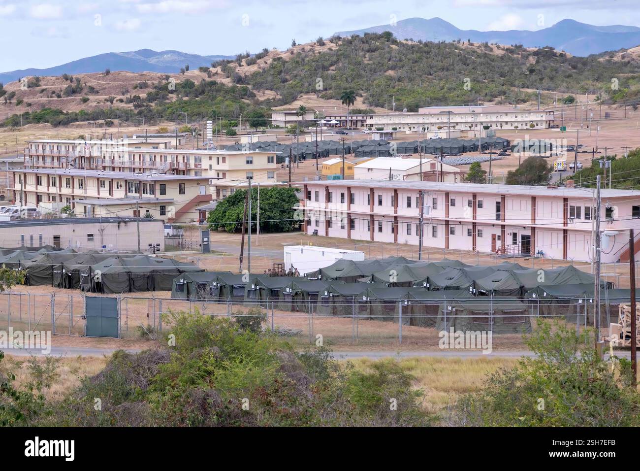 GUANTÁNAMO BAY, Cuba - un alieno illegale che tiene tende alla stazione navale di Guantánamo Bay a sostegno della missione del Dipartimento della difesa e del Dipartimento della sicurezza interna per espandere il Centro operativo illegale di detenzione degli alieni durante l'operazione Southern Guard alla stazione navale di Guantánamo Bay, Cuba. Sotto la direzione del presidente degli Stati Uniti al Dipartimento della sicurezza interna (DHS) e al Dipartimento della difesa, i membri del servizio militare degli Stati Uniti stanno sostenendo le operazioni di rimozione guidate dal DHS alla Naval Station Guantanamo Bay. Foto Stock