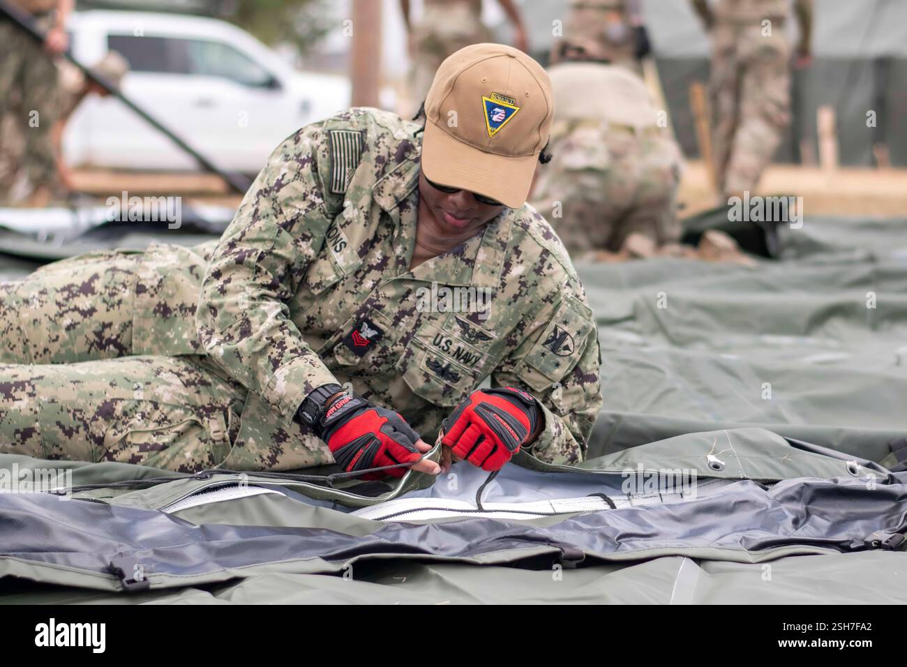 I marinai della Marina degli Stati Uniti e i soldati dell'esercito hanno allestito tende presso la stazione navale di Guantanamo Bay a sostegno della missione del Dipartimento della difesa e del Dipartimento della sicurezza interna per espandere il Centro operativo illegale di detenzione degli alieni durante l'operazione Southern Guard presso la stazione navale di Guantanamo Bay, Cuba. Sotto la direzione del presidente degli Stati Uniti al Dipartimento della sicurezza interna (DHS) e al Dipartimento della difesa, i membri del servizio militare degli Stati Uniti stanno sostenendo le operazioni di rimozione guidate dal DHS alla Naval Station Guantanamo Bay. Foto Stock