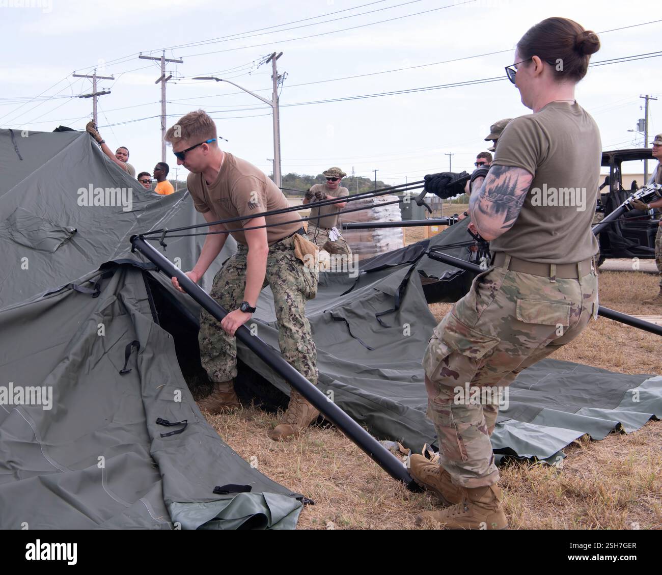 I marinai della Marina degli Stati Uniti e i soldati dell'esercito hanno allestito tende presso la stazione navale di Guantanamo Bay a sostegno della missione del Dipartimento della difesa e del Dipartimento della sicurezza interna per espandere il Centro operativo illegale di detenzione degli alieni durante l'operazione Southern Guard presso la stazione navale di Guantanamo Bay, Cuba. Sotto la direzione del presidente degli Stati Uniti al Dipartimento della sicurezza interna (DHS) e al Dipartimento della difesa, i membri del servizio militare degli Stati Uniti stanno sostenendo le operazioni di rimozione guidate dal DHS alla Naval Station Guantanamo Bay. Foto Stock