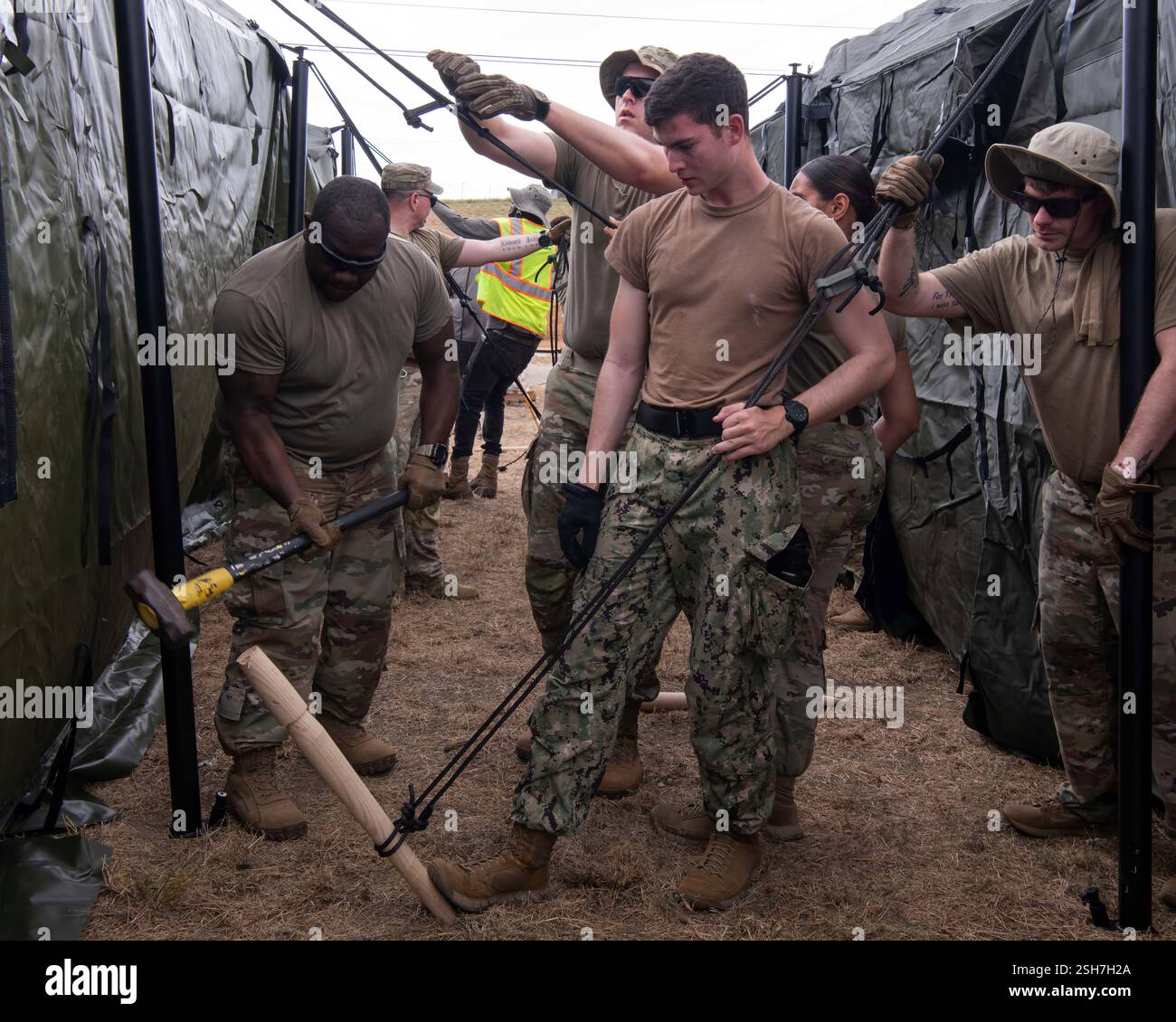 I marinai della Marina degli Stati Uniti e i soldati dell'esercito hanno allestito tende presso la stazione navale di Guantanamo Bay a sostegno della missione del Dipartimento della difesa e del Dipartimento della sicurezza interna per espandere il Centro operativo illegale di detenzione degli alieni durante l'operazione Southern Guard presso la stazione navale di Guantanamo Bay, Cuba. Sotto la direzione del presidente degli Stati Uniti al Dipartimento della sicurezza interna (DHS) e al Dipartimento della difesa, i membri del servizio militare degli Stati Uniti stanno sostenendo le operazioni di rimozione guidate dal DHS alla Naval Station Guantanamo Bay. Foto Stock