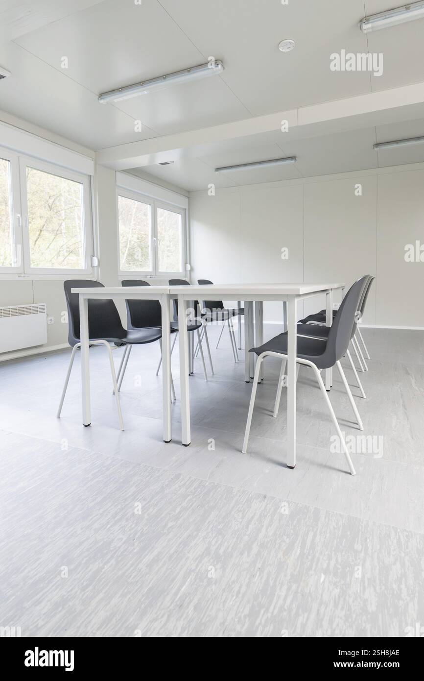 Luminosa sala riunioni con sedie e tavoli moderni, grandi finestre e colori neutri, sistemazione per rifugiati di BeerMiss, Calmbach, Foresta Nera, Germania Foto Stock
