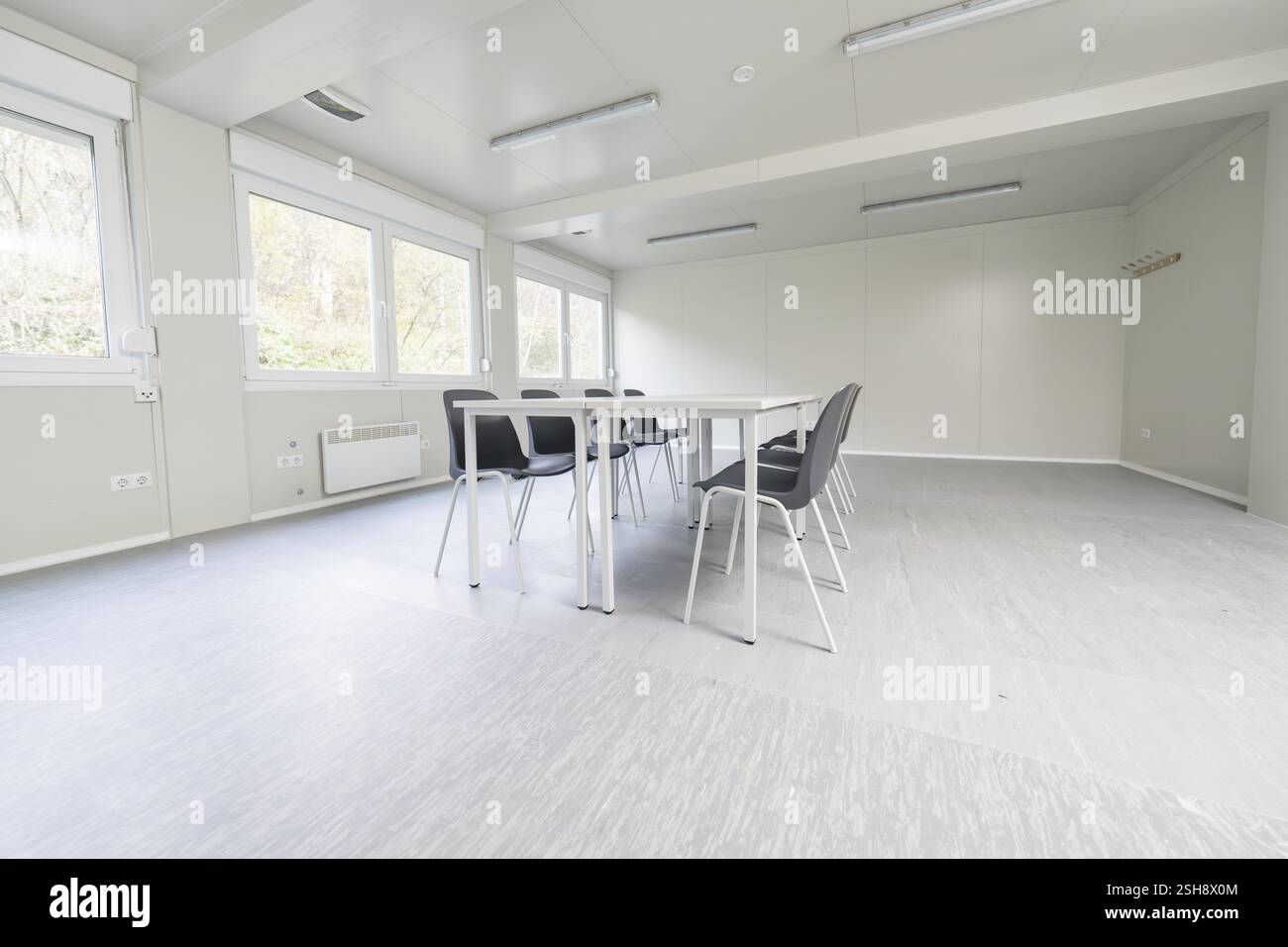 Moderna sala conferenze con tavoli bianchi e sedie nere, grandi finestre che offrono luminosità, alloggi per rifugiati di BeerMiss, Calmbach, Foresta Nera, G. Foto Stock