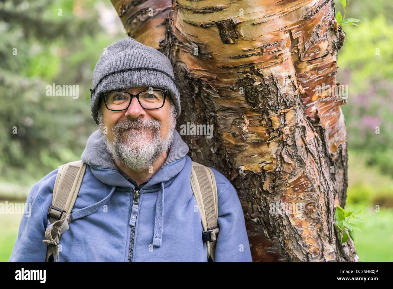 Ritratto del baby boomer con barba e baffi grigi e scintille infantili negli occhi spalancati. Foto Stock