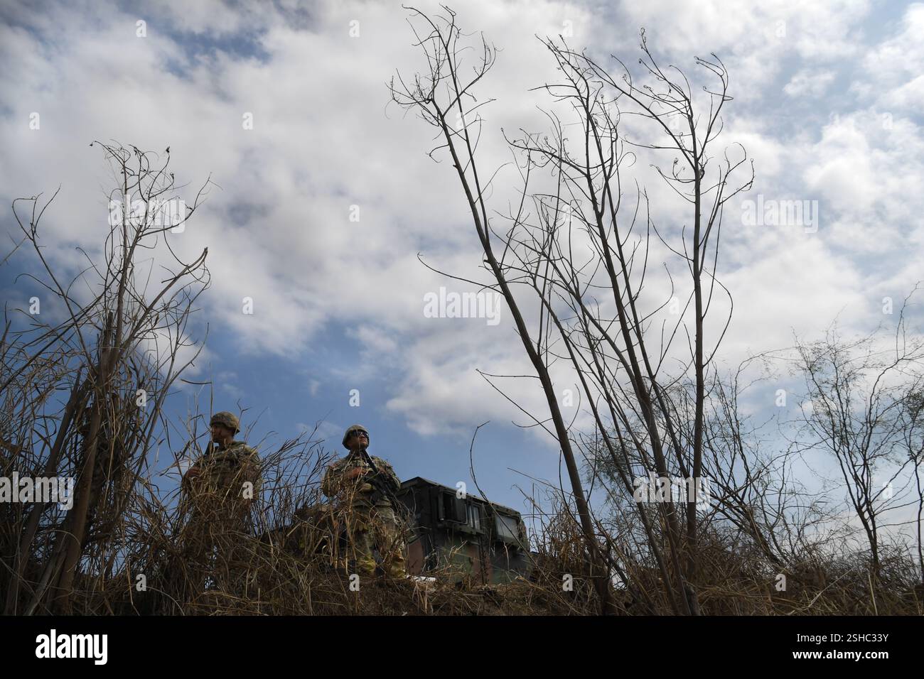 I soldati statunitensi con la Guardia Nazionale dell'Esercito del Texas guardano oltre il fiume Rio grande vicino a Roma, Texas, mentre prendono parte alle operazioni di confine con la Texas Tactical Border Force, 5 febbraio 2025. Il TTBF, composto da membri della Guardia Nazionale del Texas in uno stato di servizio attivo, lavora con funzionari delle forze dell'ordine statali e federali, tra cui la pattuglia di frontiera degli Stati Uniti, con una missione continua per scoraggiare, individuare e fermare i valichi di frontiera illegali e per interdire i criminali transnazionali. (Foto dell'esercito degli Stati Uniti del sergente Jon Soucy di prima classe) Foto Stock