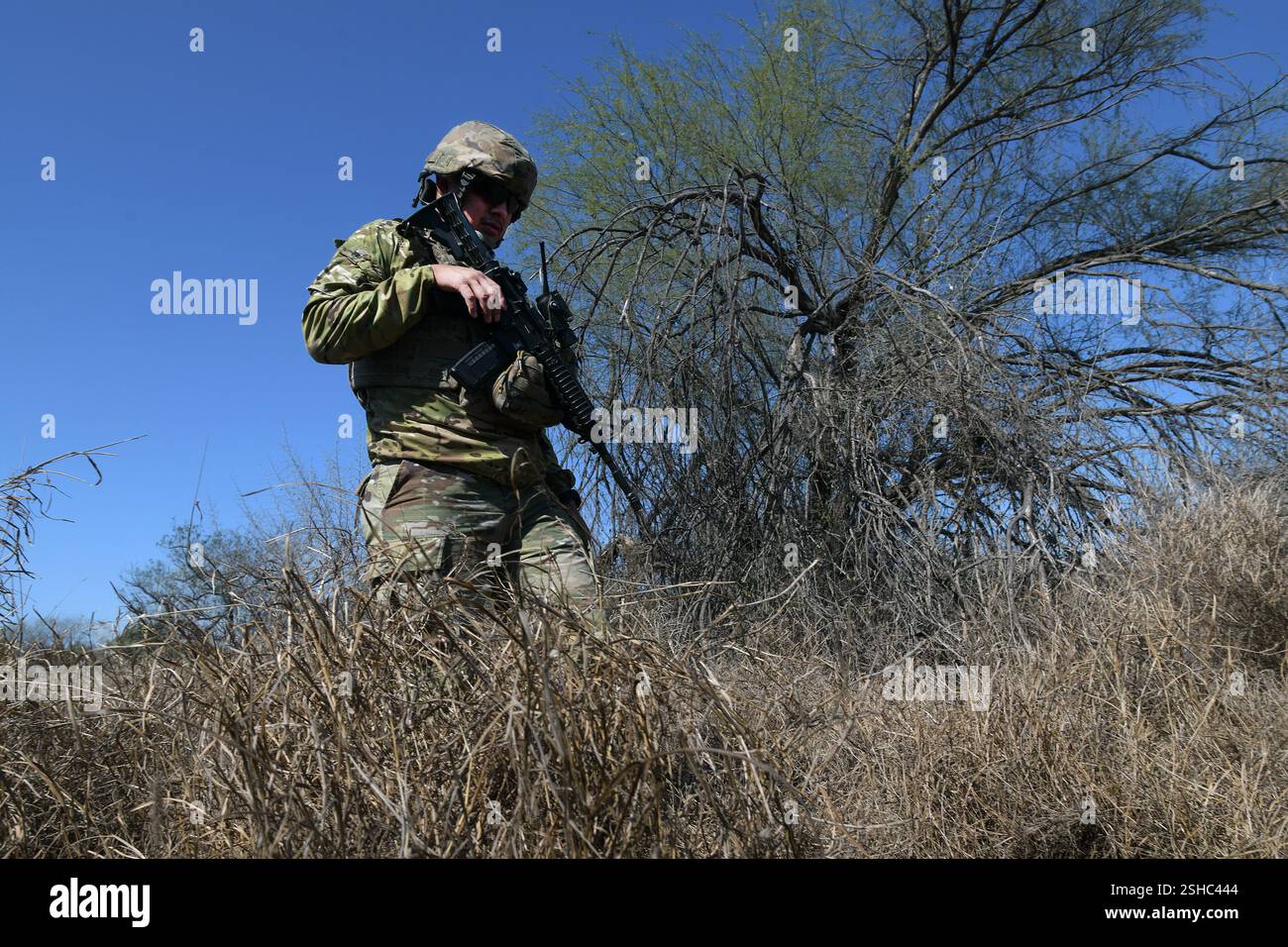 Marc Lopez, con la Texas Army National Guard, controlla l'attività dei migranti e le prove di valichi di frontiera illegali in un'area boscosa lungo il confine meridionale vicino a McAllen, Texas, come parte della Texas Tactical Border Force, 3 febbraio 2025. Il TTBF è composto da membri della Guardia Nazionale del Texas in uno stato di servizio attivo che lavorano con funzionari delle forze dell'ordine statali e federali, tra cui la pattuglia di frontiera degli Stati Uniti, con una missione continua per scoraggiare, individuare e fermare i valichi di frontiera illegali e per interdire i criminali transnazionali. (Foto dell'esercito degli Stati Uniti del sergente Jon Soucy di prima classe) Foto Stock