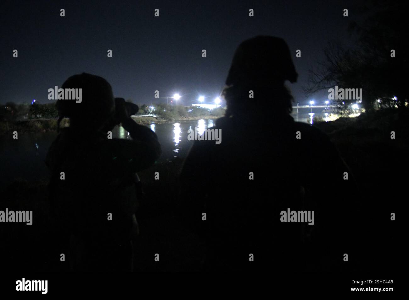 Soldati statunitensi con la Texas Army National Guard, assegnata alla Texas Tactical Border Force, osservano come un gruppo sul lato messicano del fiume Rio grande inizia un tentativo di attraversare illegalmente gli Stati Uniti Roma, Texas, 5 febbraio 2025. Il TTBF, composto da membri della Guardia Nazionale del Texas in uno stato di servizio attivo, si trasferì per intercettare il gruppo una volta che raggiunsero le banche degli Stati Uniti, come parte della loro missione di lavorare con funzionari statali e federali delle forze dell'ordine, tra cui la pattuglia di frontiera degli Stati Uniti, con una missione continua per scoraggiare, individuare e fermare i valichi di frontiera illegali e interdire le transna Foto Stock