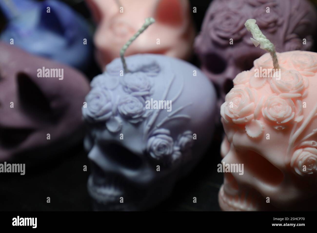 Un primo piano di candele fai da te a forma di teschio adornate con delicate incisioni floreali. Foto Stock