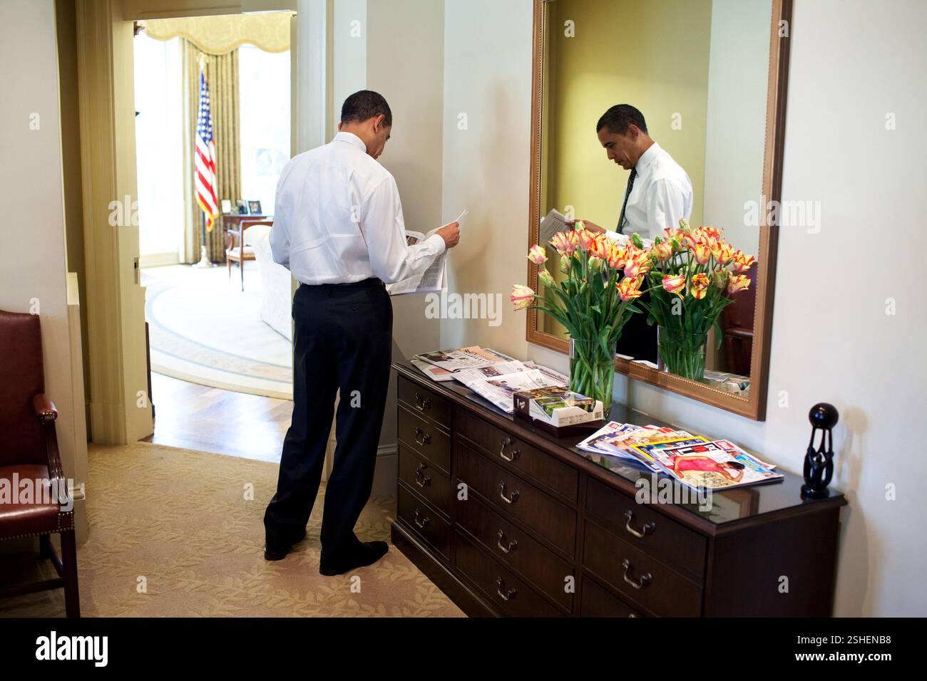 Il presidente Barack Obama legge il giornale in esterno Ufficio Ovale 3/5/09. Gazzetta White House Photo by Pete Souza Foto Stock