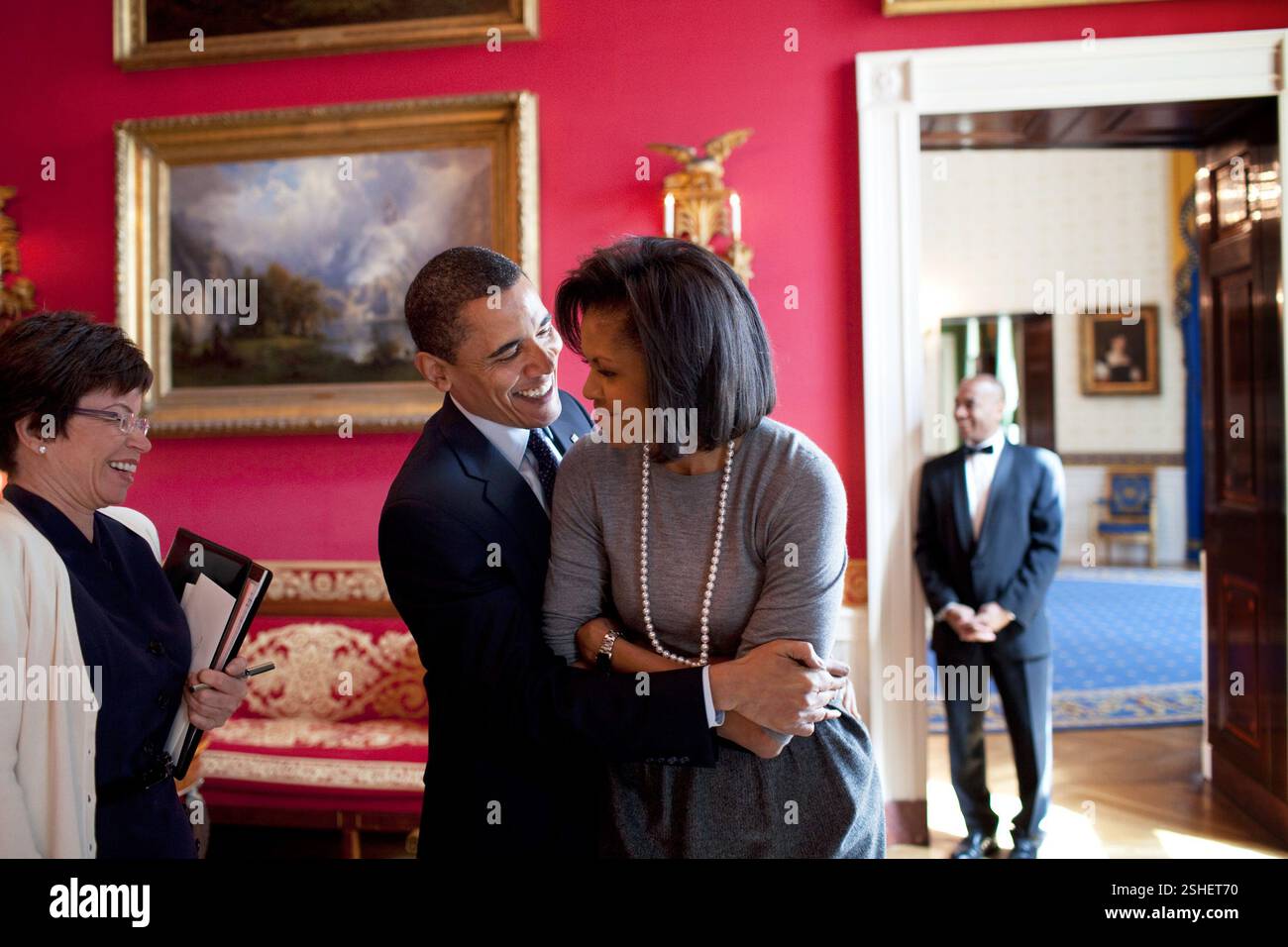 Il presidente Barack Obama abbracci la First Lady Michelle Obama nella sala rossa mentre Senior Advisor Valerie Jarrett sorrisi prima del quotidiano nazionale Publishers Association (NNPA) reception 3/20/09. Gazzetta White House Photo by Pete Souza Foto Stock