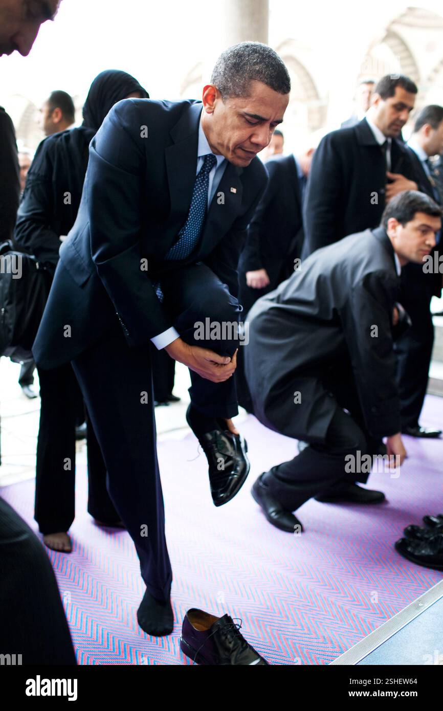 Il presidente Barack Obama rimuove le sue scarpe come egli si prepara a visitare la Moschea Blu il 7 aprile 2009, a Istanbul. Gazzetta White House Photo by Pete Souza Foto Stock