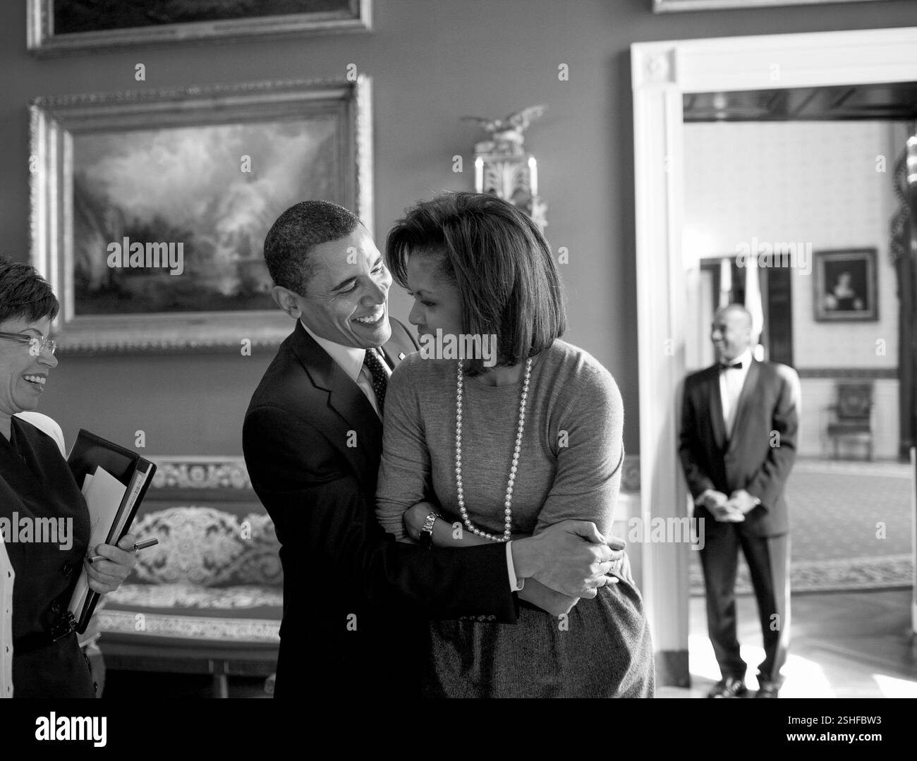 Il presidente Barack Obama abbracci la First Lady Michelle Obama nella sala rossa mentre Senior Advisor Valerie Jarrett sorrisi prima del quotidiano nazionale Publishers Association (NNPA) reception 3/20/09. Gazzetta White House Photo by Pete Souza Foto Stock