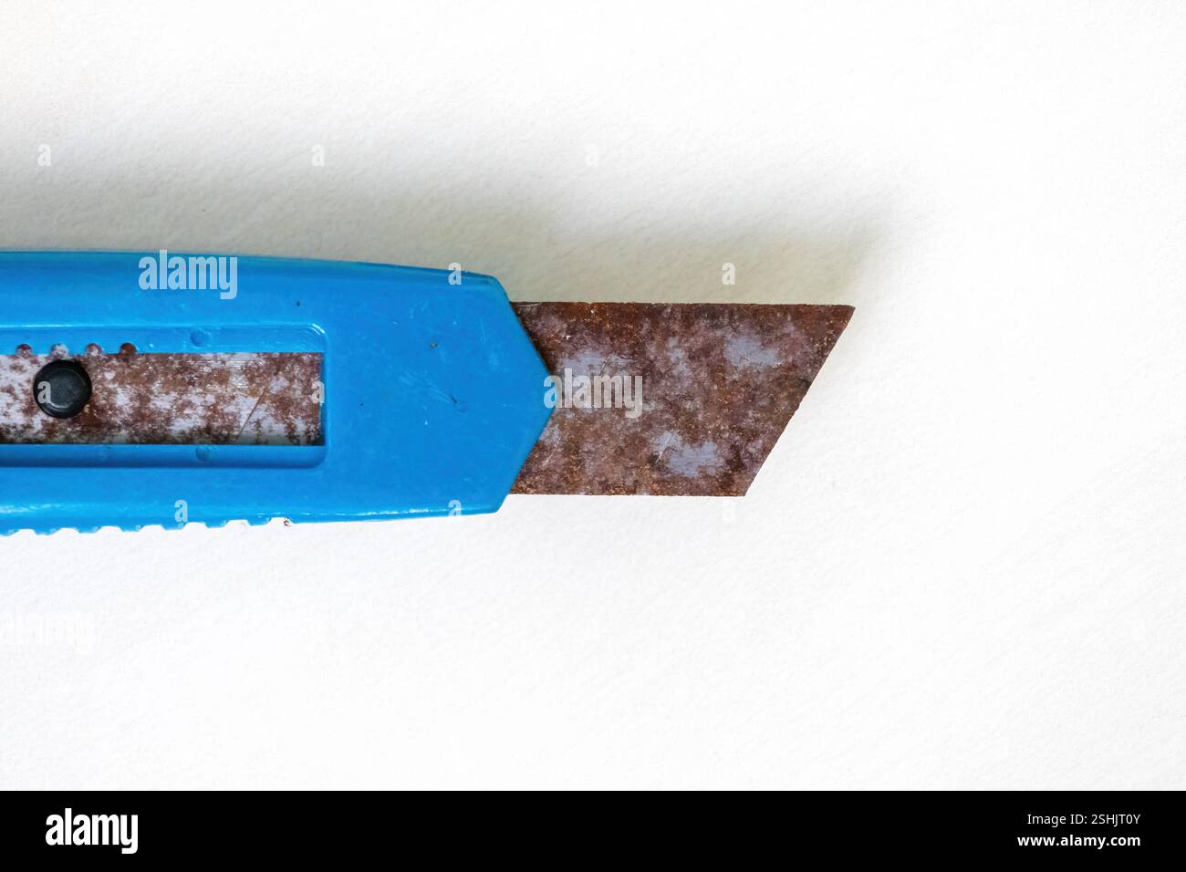 Primo piano di un vecchio coltello da taglio blu inutilizzato con ruggine, isolato su sfondo bianco. Vista dall'alto. Foto Stock