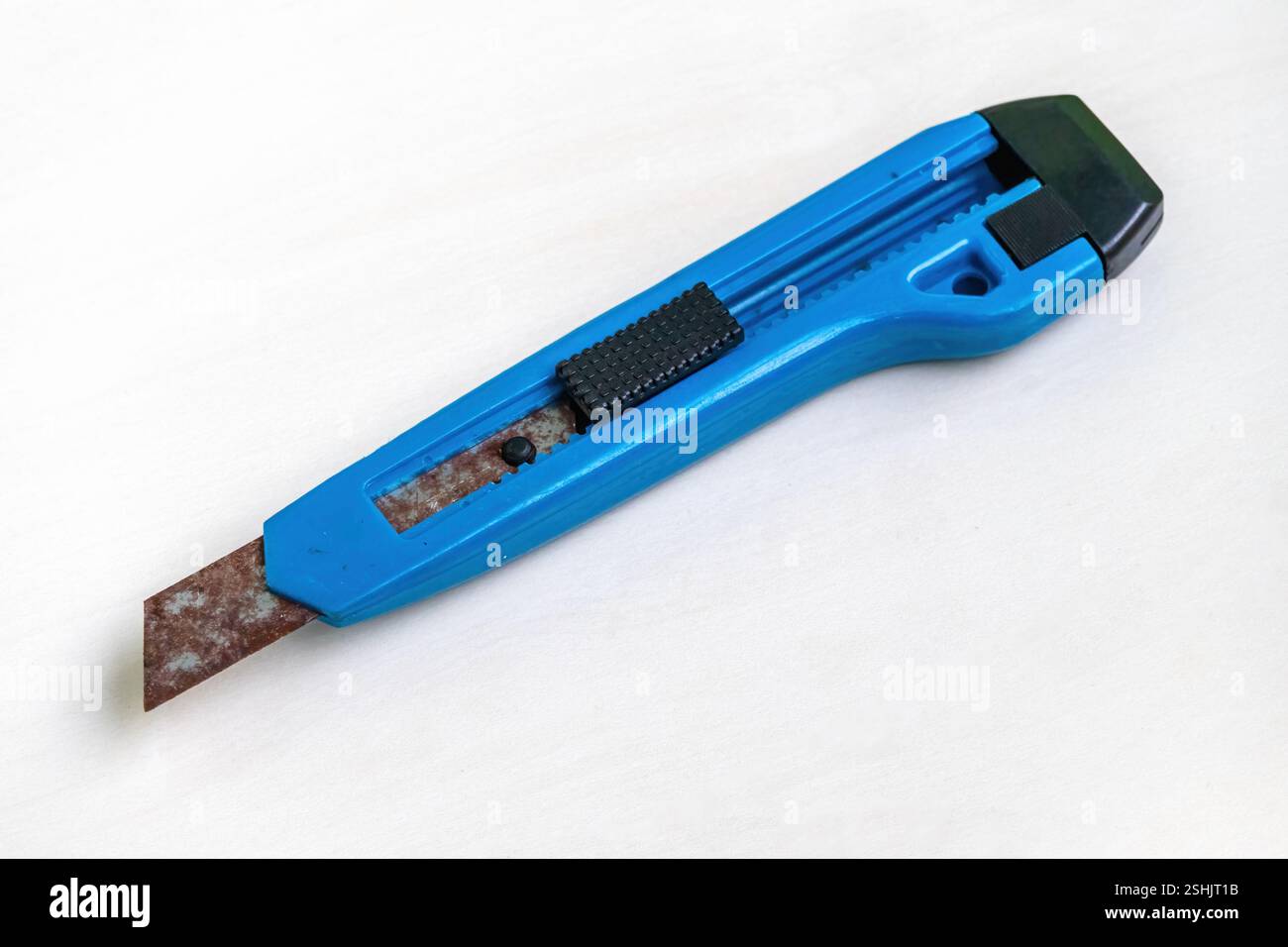 Un vecchio coltello da taglio blu arrugginito su sfondo bianco. Foto Stock
