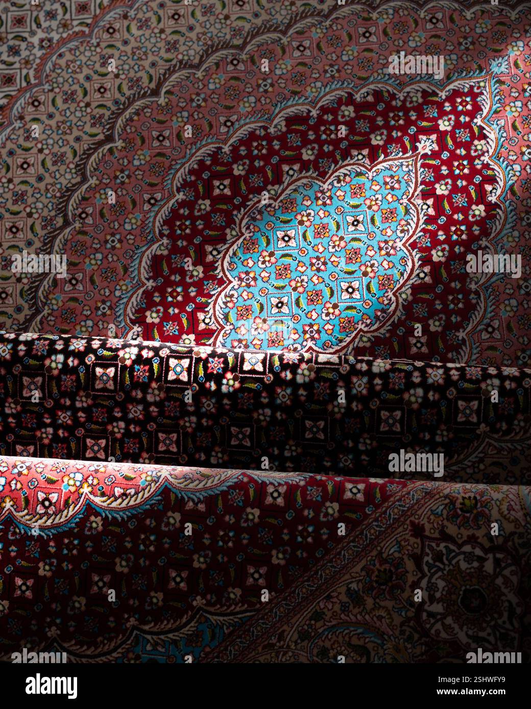 Intricato tappeto persiano con motivi floreali illuminati dalla luce del sole, che mostrano colori vivaci e artigianato tradizionale Foto Stock