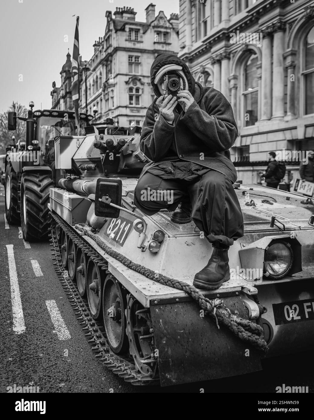 Un'immagine in bianco e nero di un fotografo in cima a un carro armato a Londra, durante la protesta degli agricoltori contro il nuovo piano Farming Inheritance Tax. Foto Stock