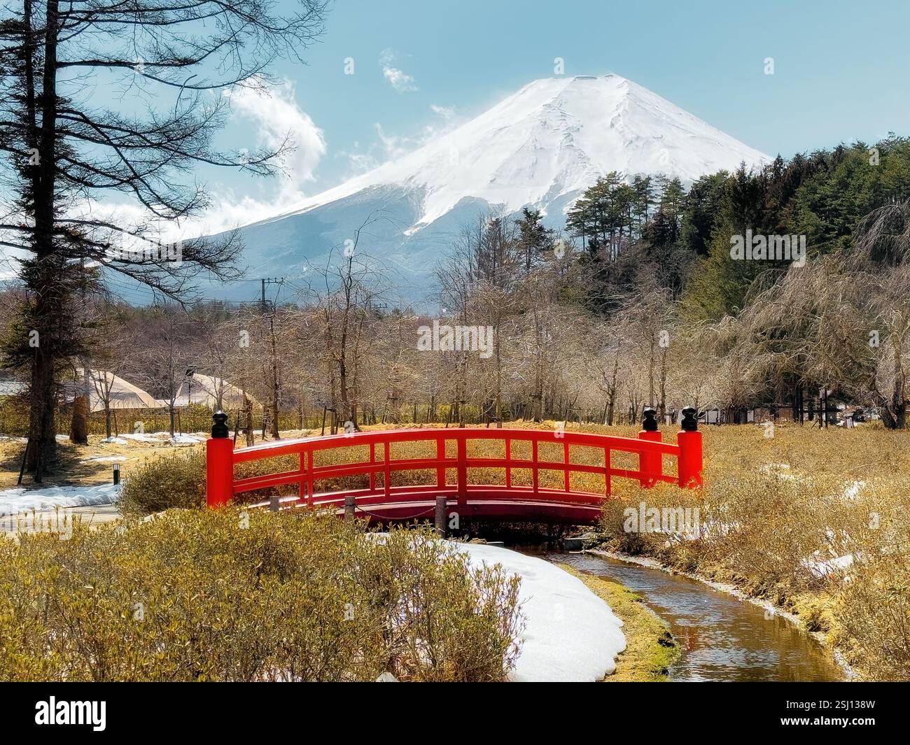 Monte Fuji innevato in Giappone all'inizio della primavera. Tipico paesaggio giapponese con l'iconico Fujisan e il tradizionale ponte rosso in primo piano. - Immagine stock catturata con smartphone