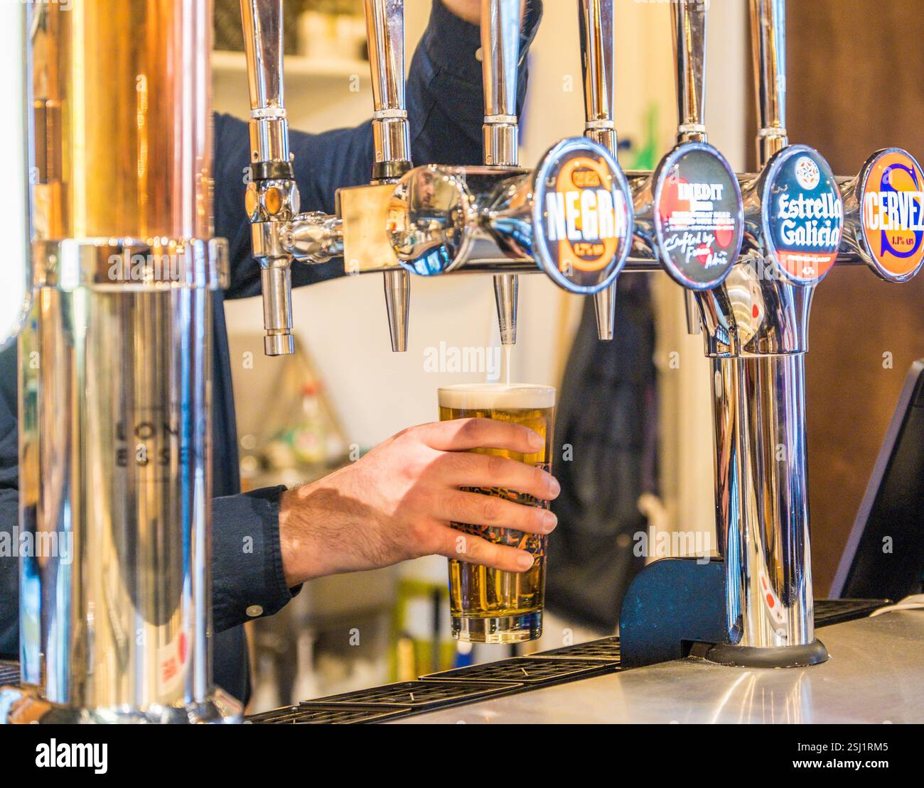 Tirando una pinta in un bar, Regno Unito Foto Stock