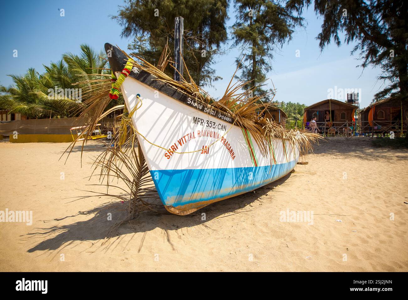 Palme e barche dei pescatori sulle sabbie dorate della spiaggia di Agonda a Goa, India Foto Stock