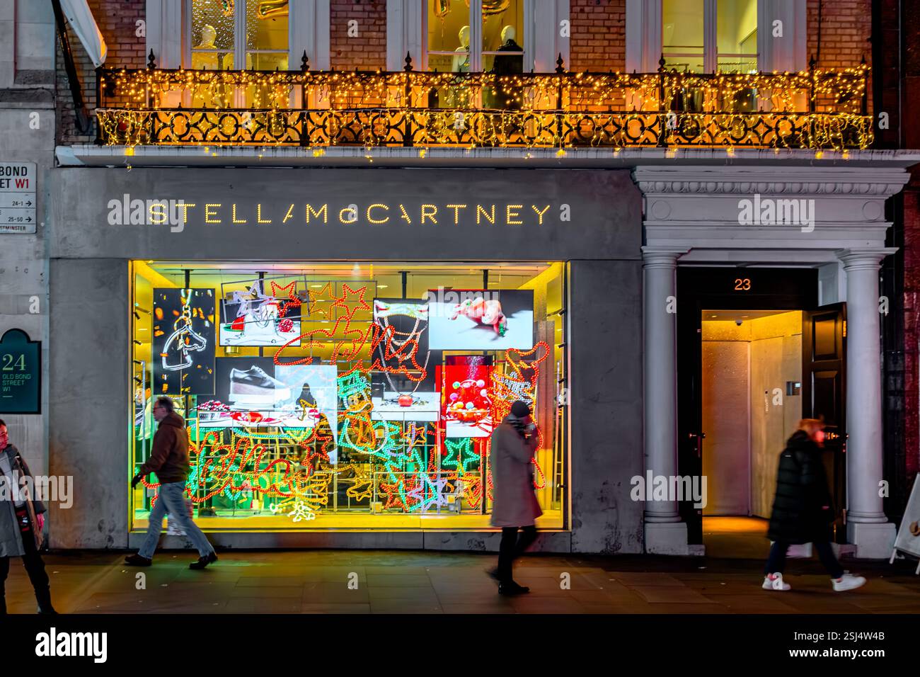 Persone che camminano accanto al negozio Stella McCartney in Old Bond Street a Natale, Mayfair, London W1 Foto Stock