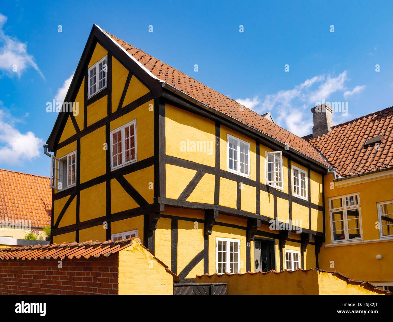 Casa a due piani gialla a graticcio con tetto in tegole rosse nella città vecchia di Svendborg sull'isola di Funen, Danimarca meridionale Foto Stock