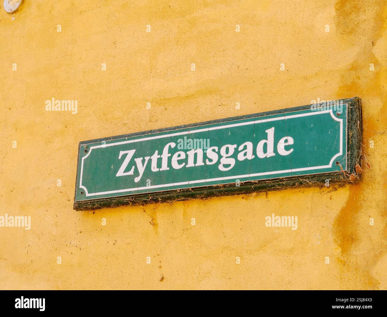 Storico cartello verde con il nome della strada sul muro giallo a Zytfensgade, Dragør Old Town, Amager Island, Capital Region, Danimarca Foto Stock